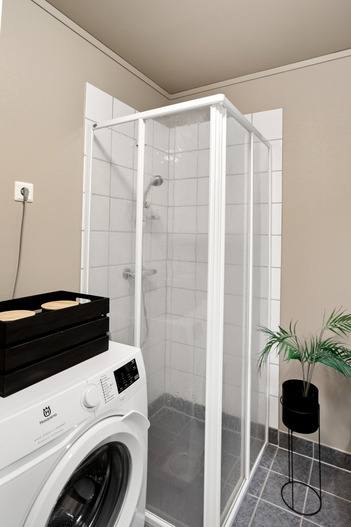 Badet er utstyrt med dusjhjørne, opplegg for vaskemaskin, toalett, servant med innredning. Galleribilde