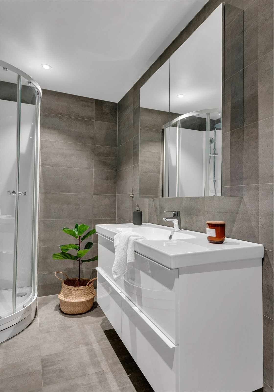 Det har en praktisk innredning med skuffer, et speilskap for oppbevaring, samt en dusjkabinett og vegghengt toalett. Galleribilde