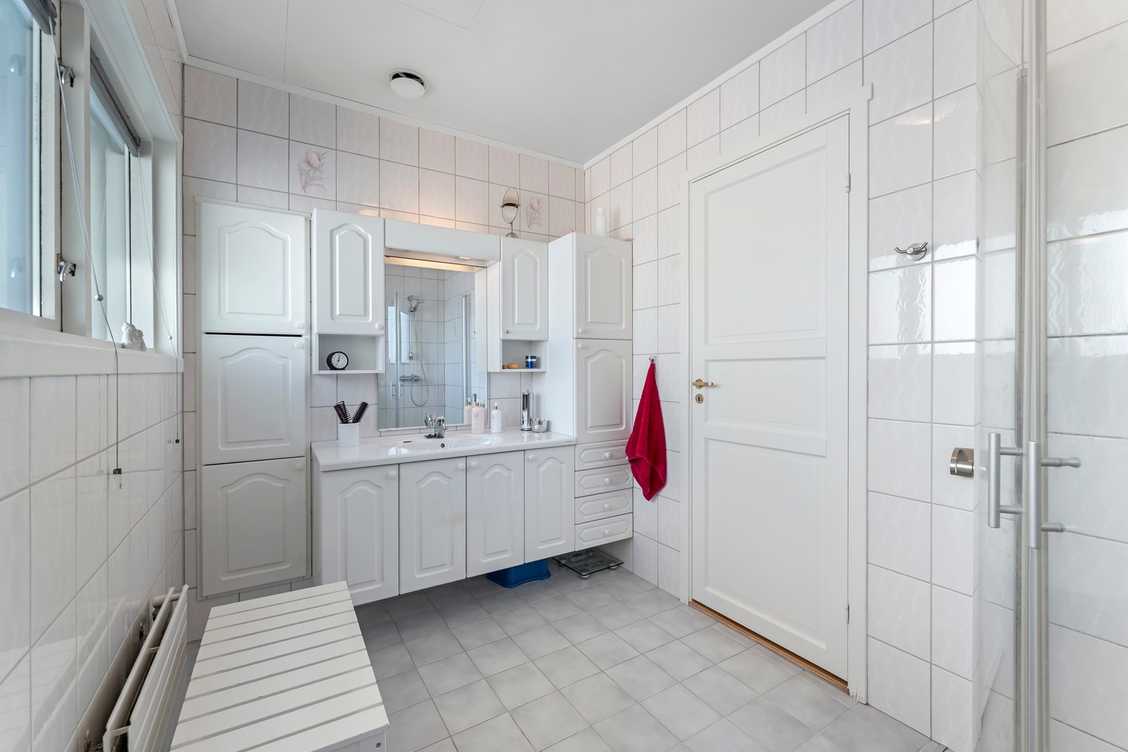 Bad i 1. etasje har flislagt gulv med vannbåren varme. Baderomsinnredning med malte profilerte fronter, heldekkende servantplate, høyskap, overskap og speil. Nedfelt servant og dusjhjørne med glassdører montert Galleribilde
