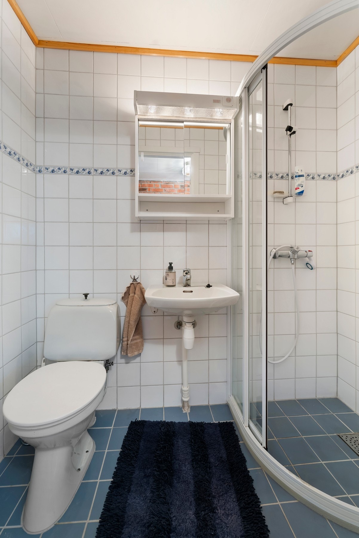 Bad i kjeller har flislagt gulv med vannbåren varme. Gulvmontert toalett, vegghengt servant og dusjhjørne Galleribilde