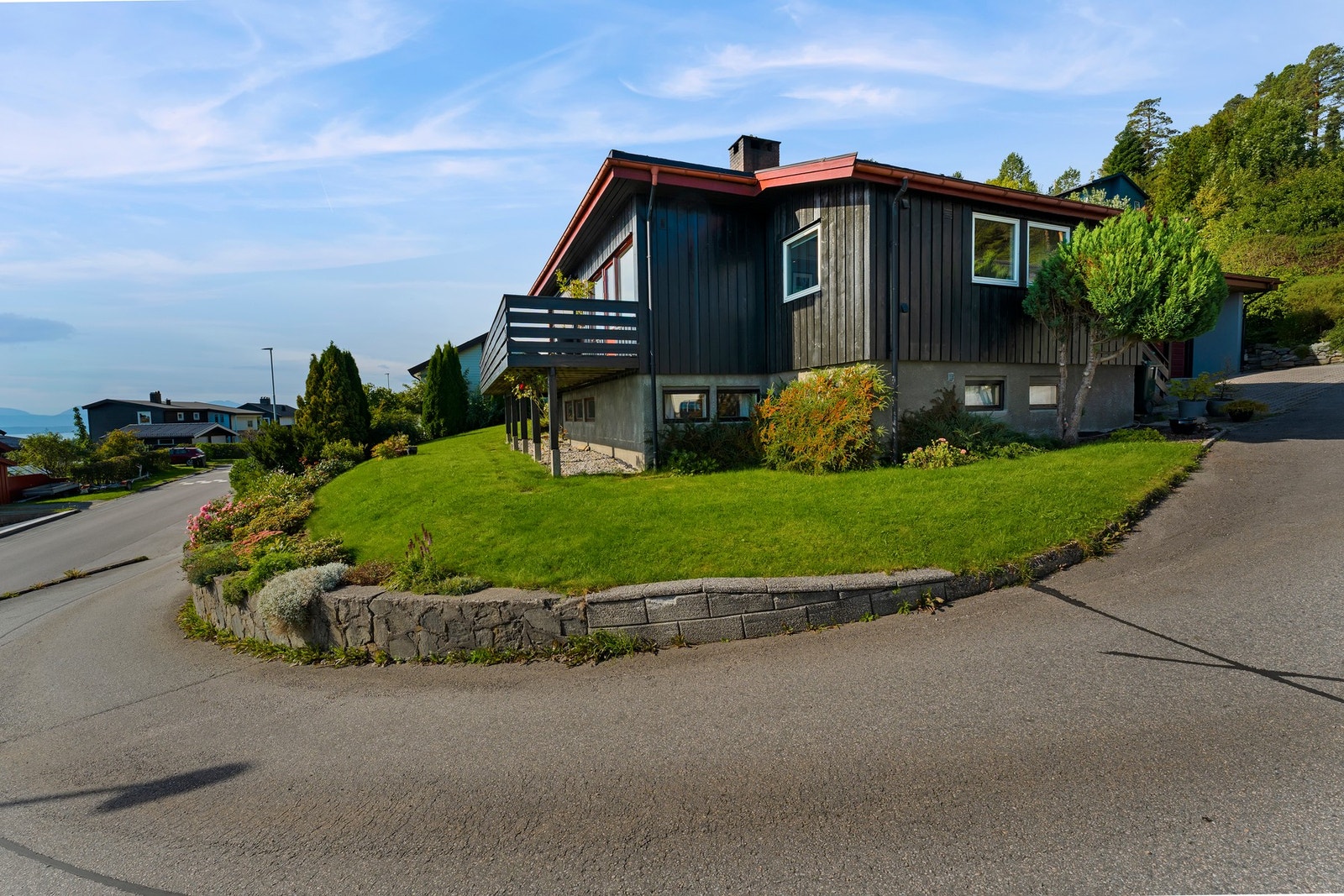 Tomten er pent opparbeidet med plenareal og prydbusker Galleribilde