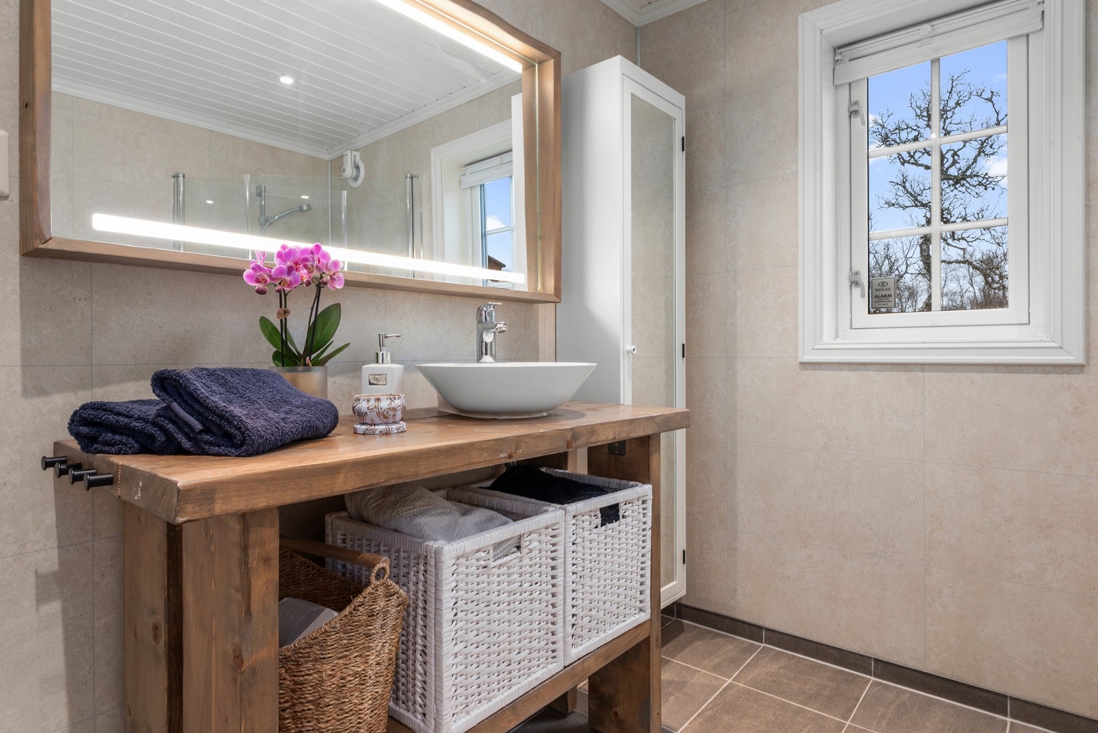 Badet er utstyrt med innfellbare dusjdører, servant i innredning, opplegg for vaskemaskin, wc og rørfordelingsskap med stoppekran. Galleribilde