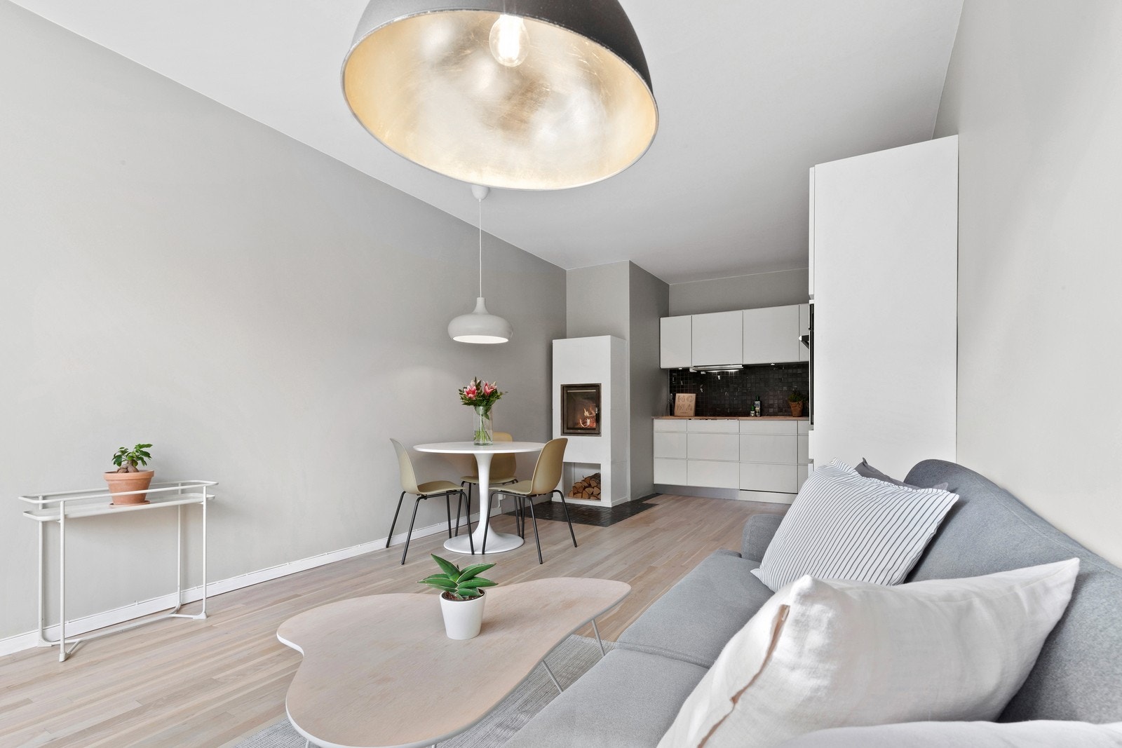 Lys og romslig stue med koselig peis og åpen løsning mot kjøkkenet. Galleribilde