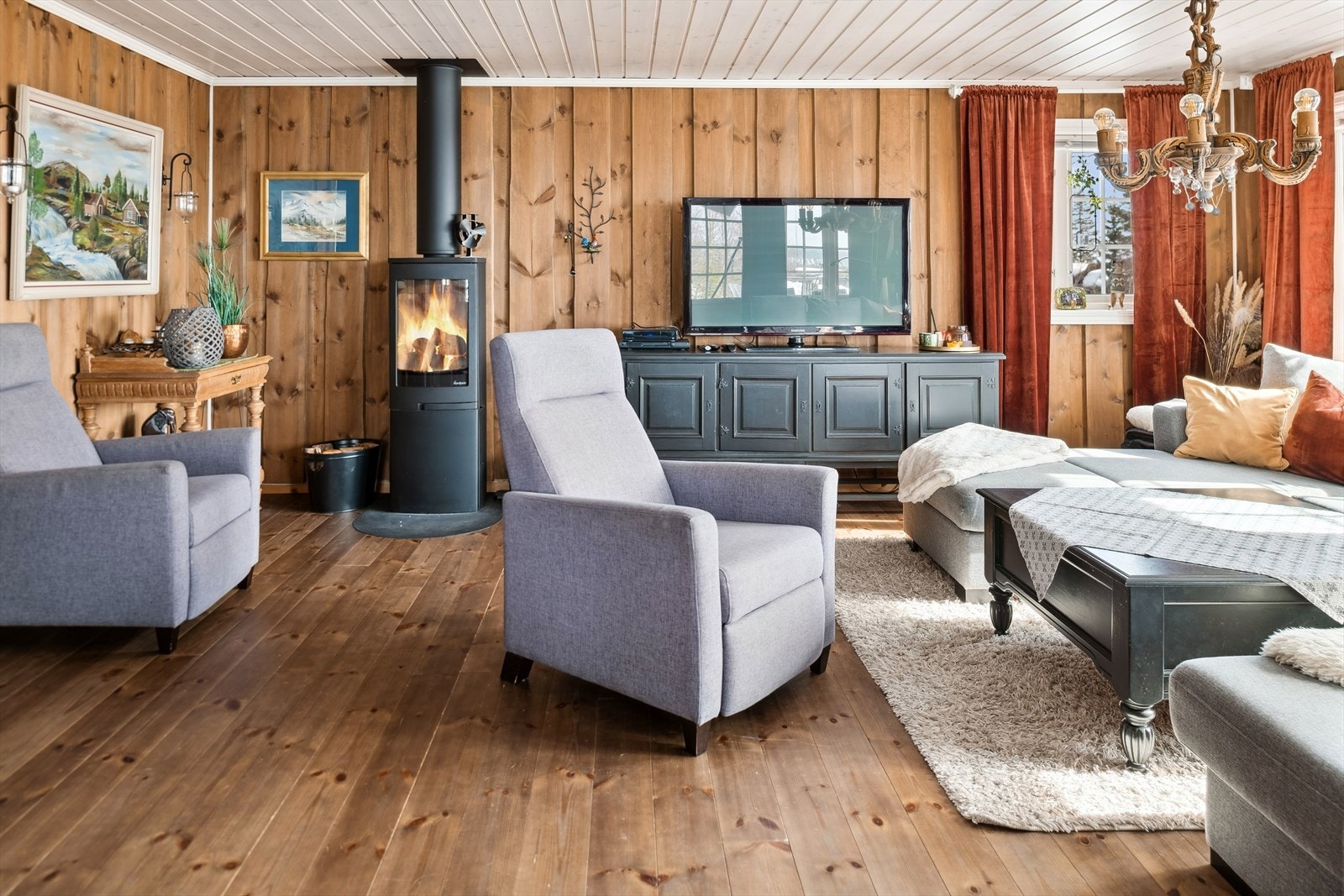 Stuen har villmarkspanel på vegg, panel i himling og heltre furu på gulv. Galleribilde