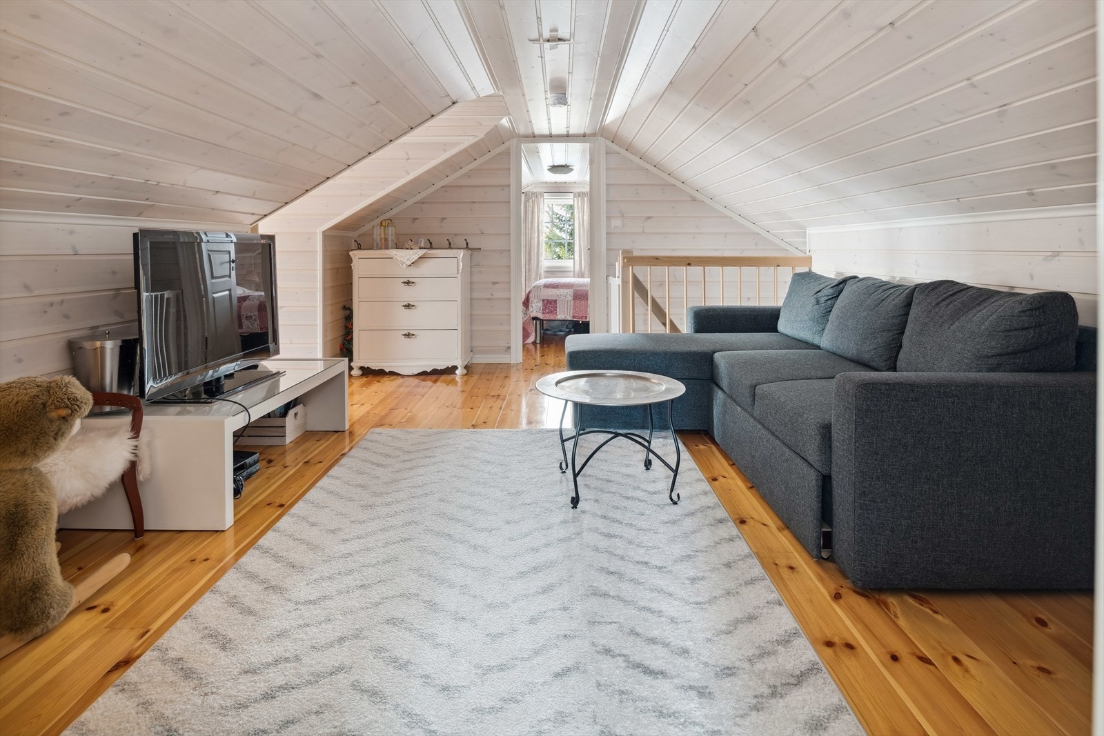 Loftsstuen på hemsen er lun og trivelig, og har lakkert heltre gulv, malt panel på vegg og i himling. Galleribilde