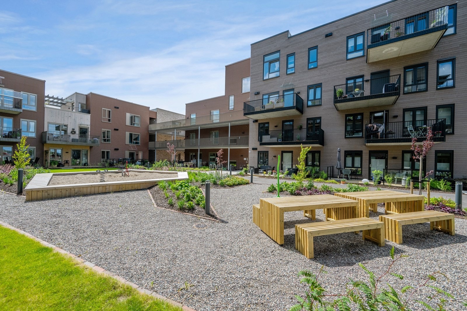 Hyggelig bakgård mot sjøen. Leiligheten ligger i 2. etg. i bygget som skimtes i midten av bildet. Galleribilde