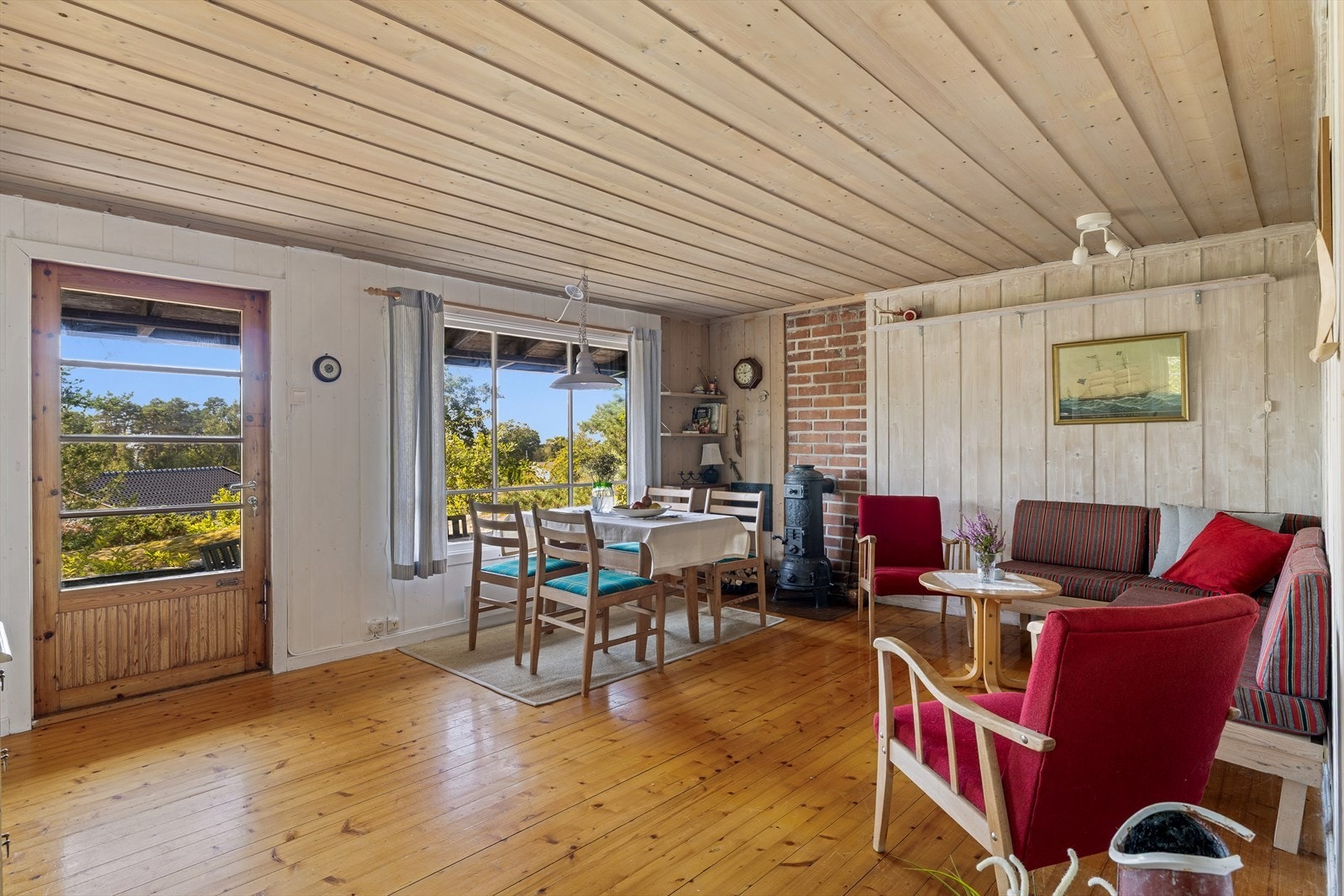 Koselig stue med panel på vegger og i taket. Tregulv Galleribilde