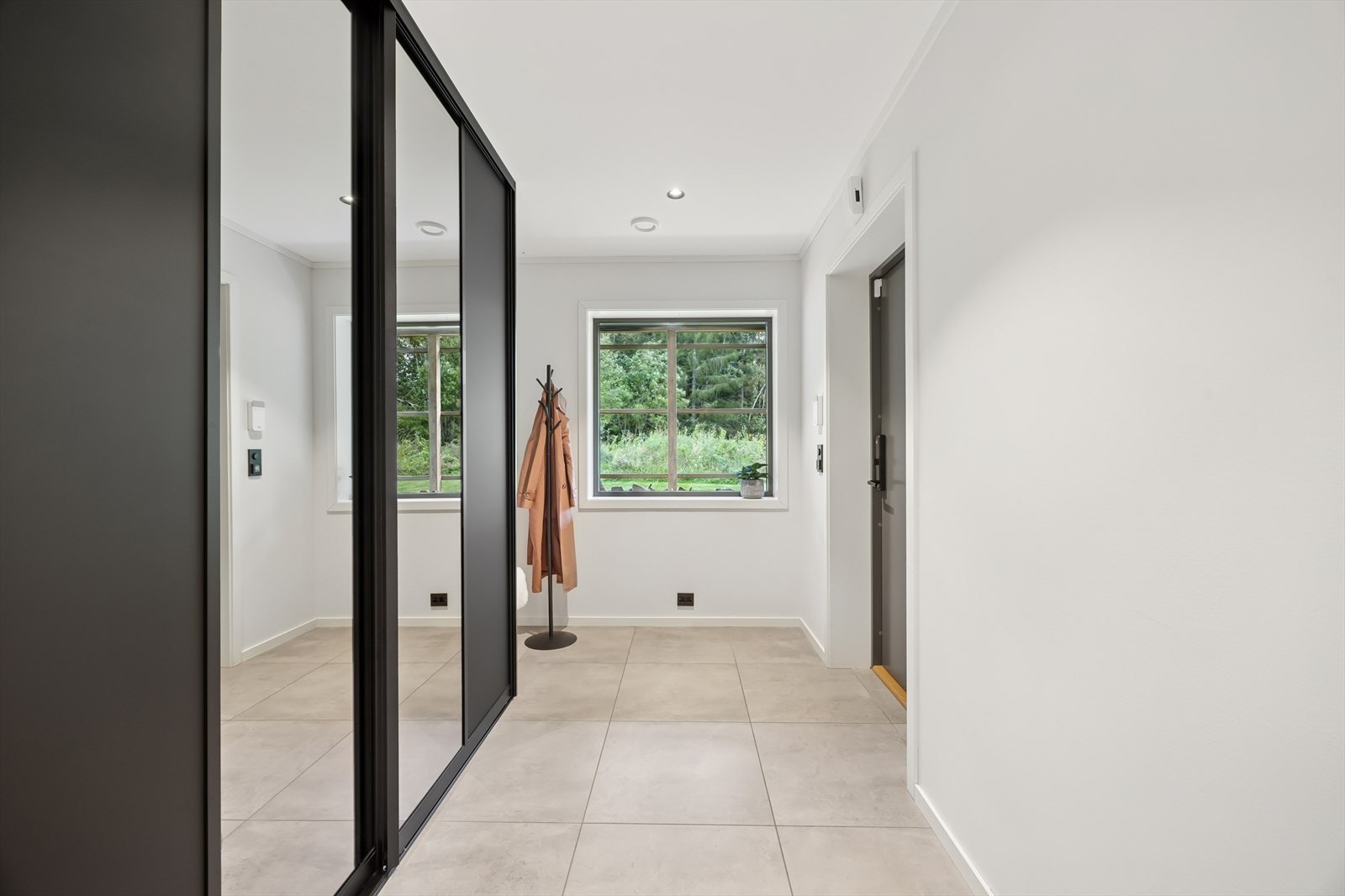 Entréen gir et godt førsteinntrykk med lyse overflater og en romslig utforming. Her er det rikelig med plass til yttertøy og sko, og et garderobeskap med speilfronter sørger for både oppbevaring og et ryddig uttrykk. Galleribilde