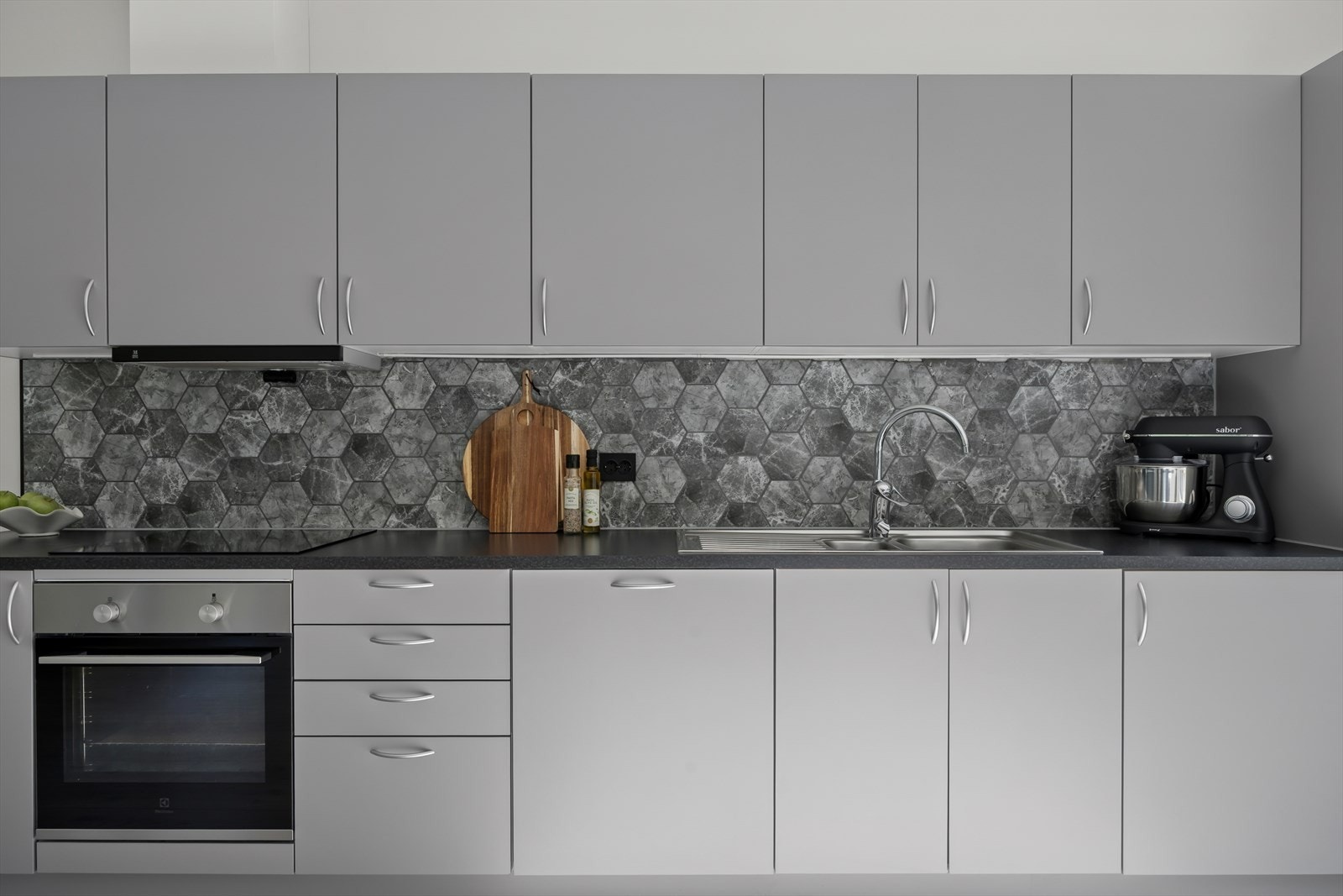 Mellom benkeplaten og overskapene er det praktiske fliser på veggen. Galleribilde