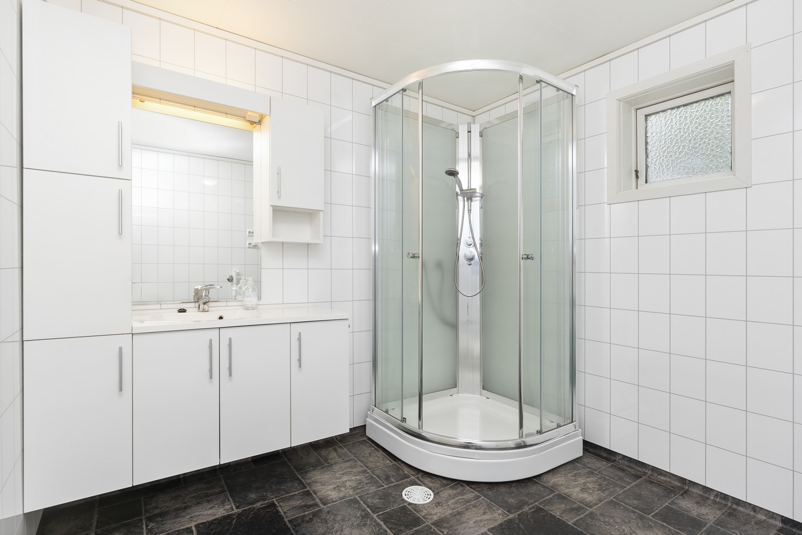 Innredning med nedfelt servant, dusjkabinett og toalett samt oppplegg til vaskemaskin. Galleribilde