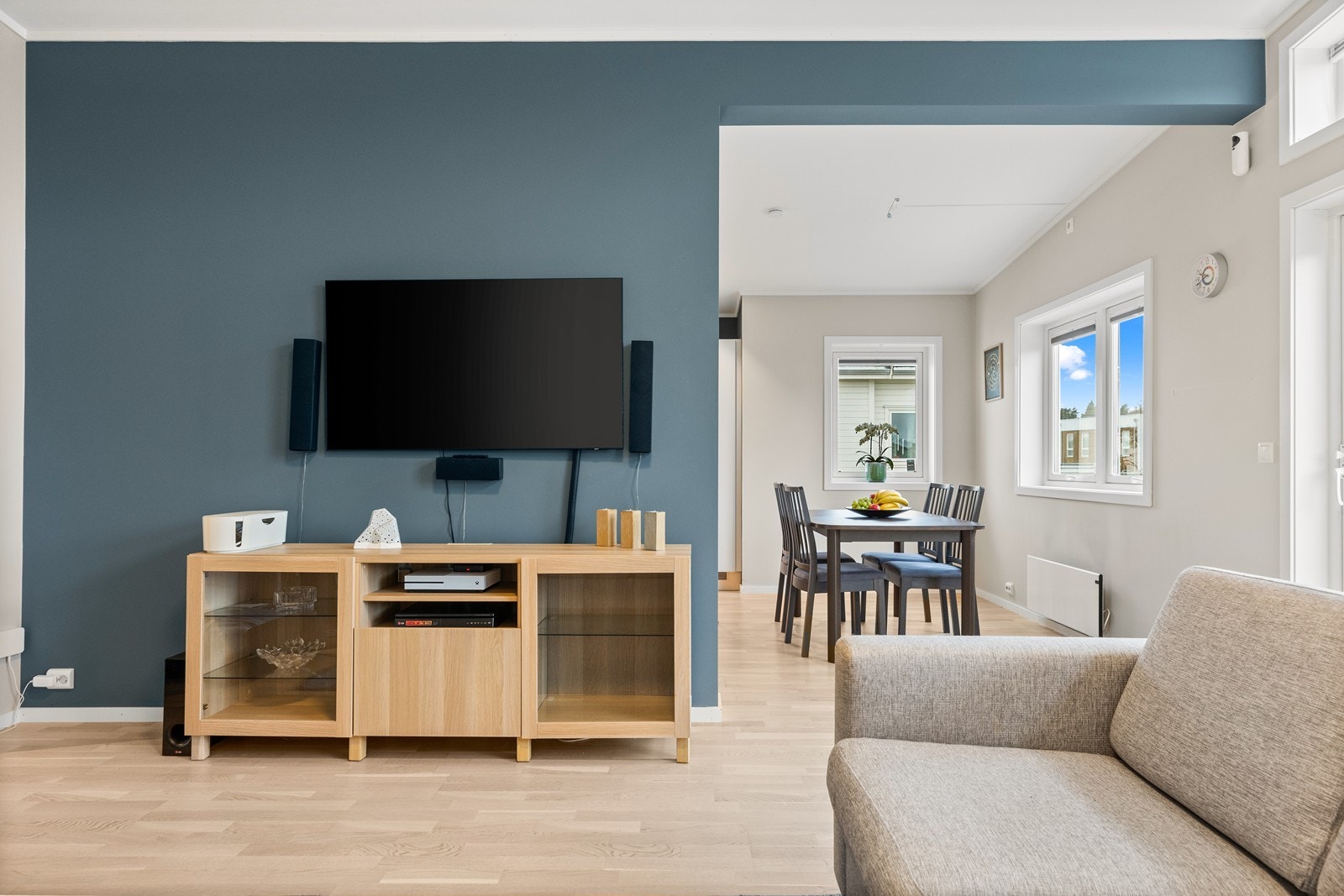 En vegg er malt i en mørkere farge for en fin kontrast, og det er åpent inn mot det romslige kjøkken med egen spisesone Galleribilde