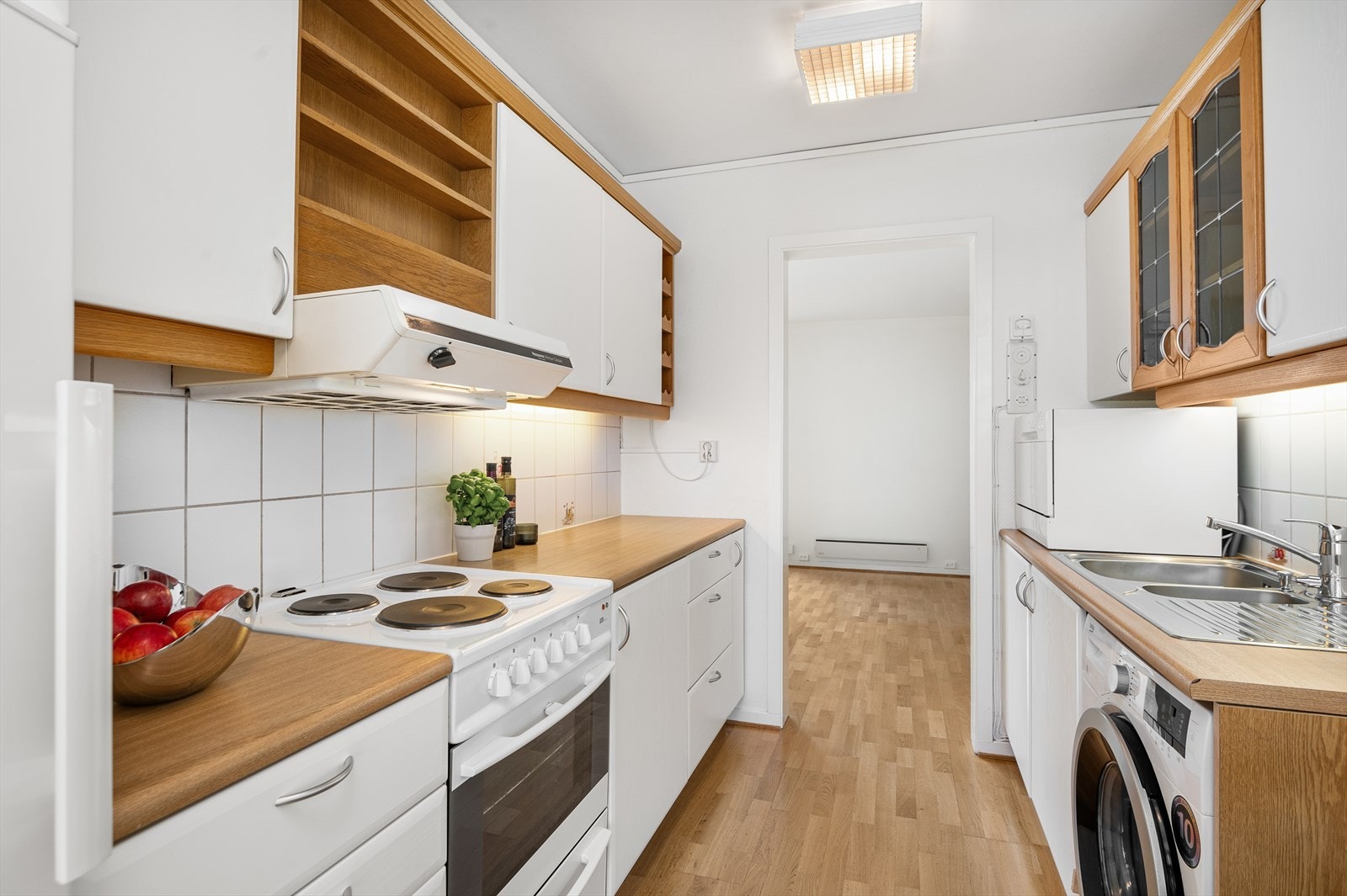 Lyst og pent kjøkken med godt med skap- og benkeplass. Galleribilde