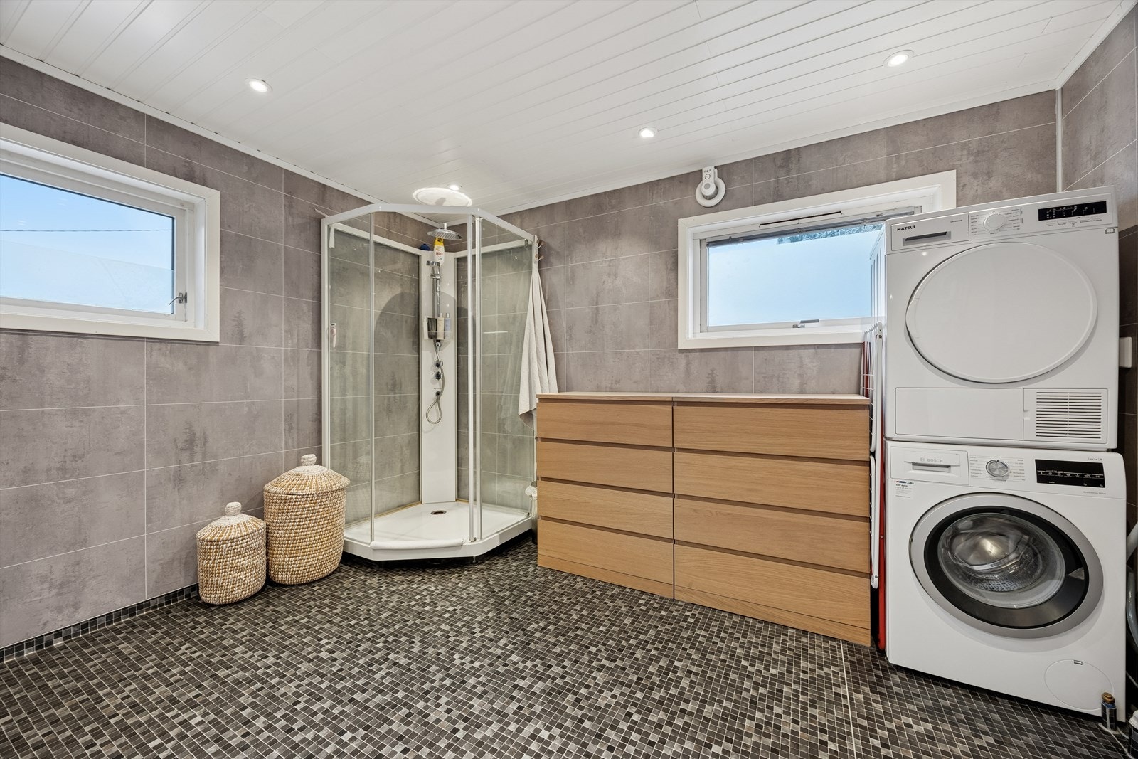 Badet er utstyrt med toalett, dusjkabinett, servant og opplegg for vaskemaskin. Galleribilde