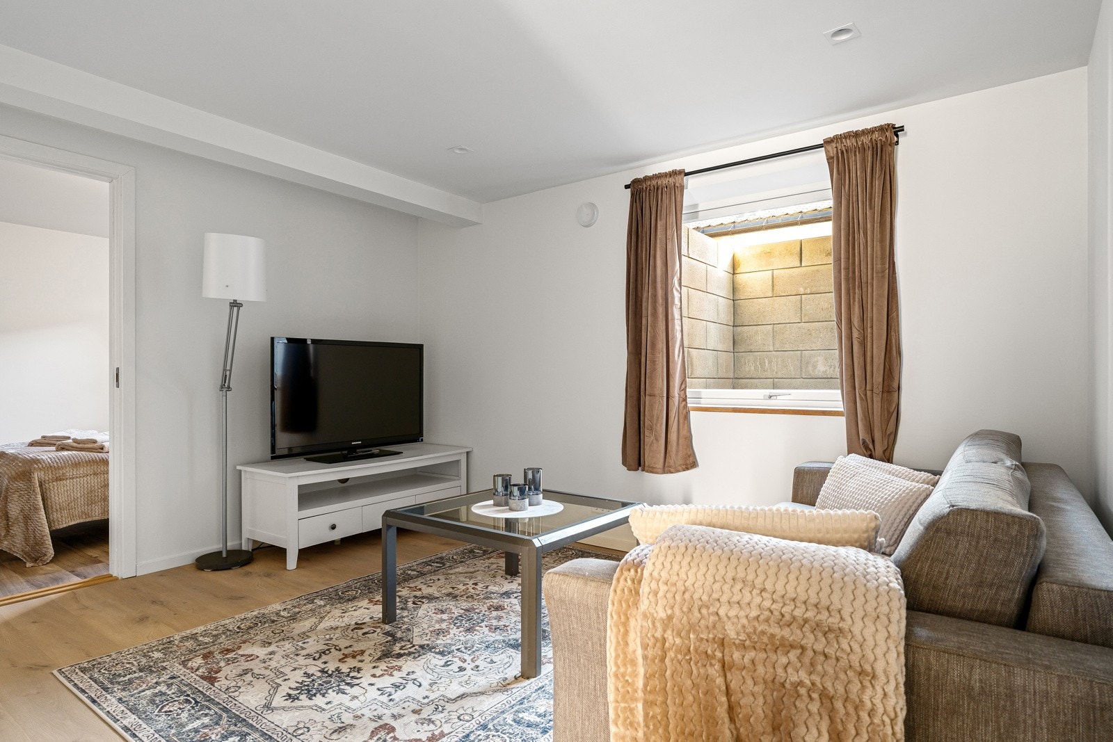 Lys og åpen stue med plass til en hyggelig sofa.