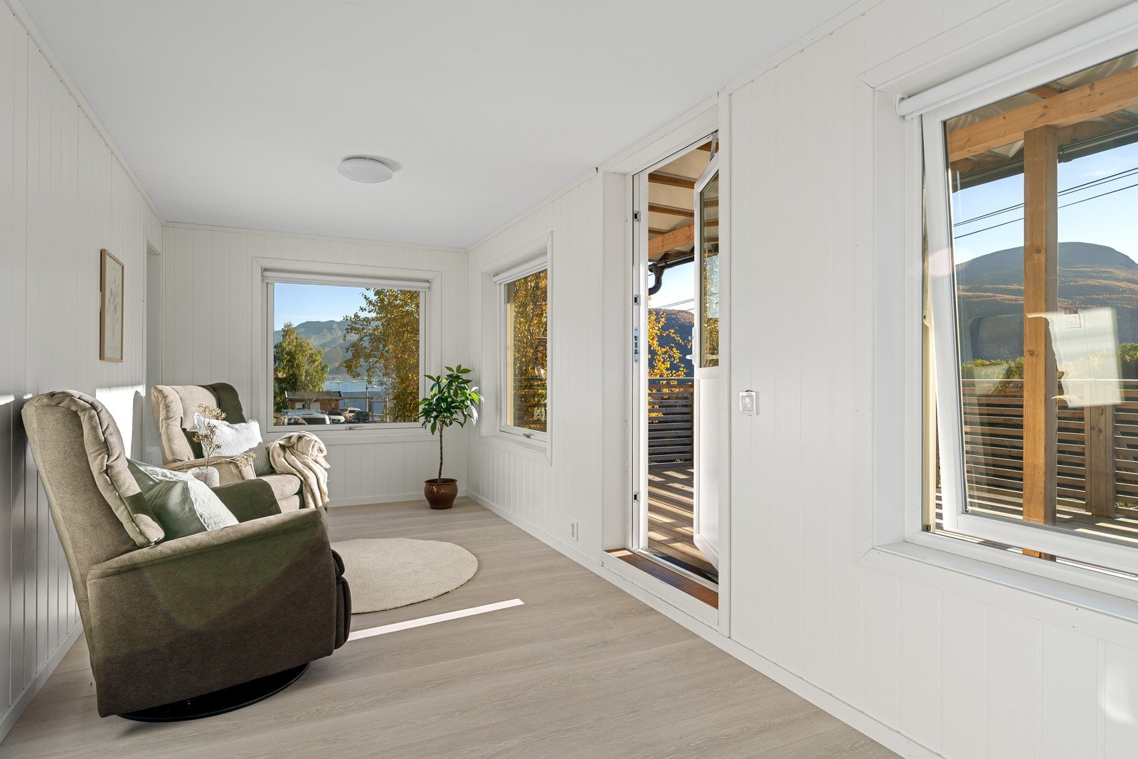 Lys stue med utgang til en solrik balkong.