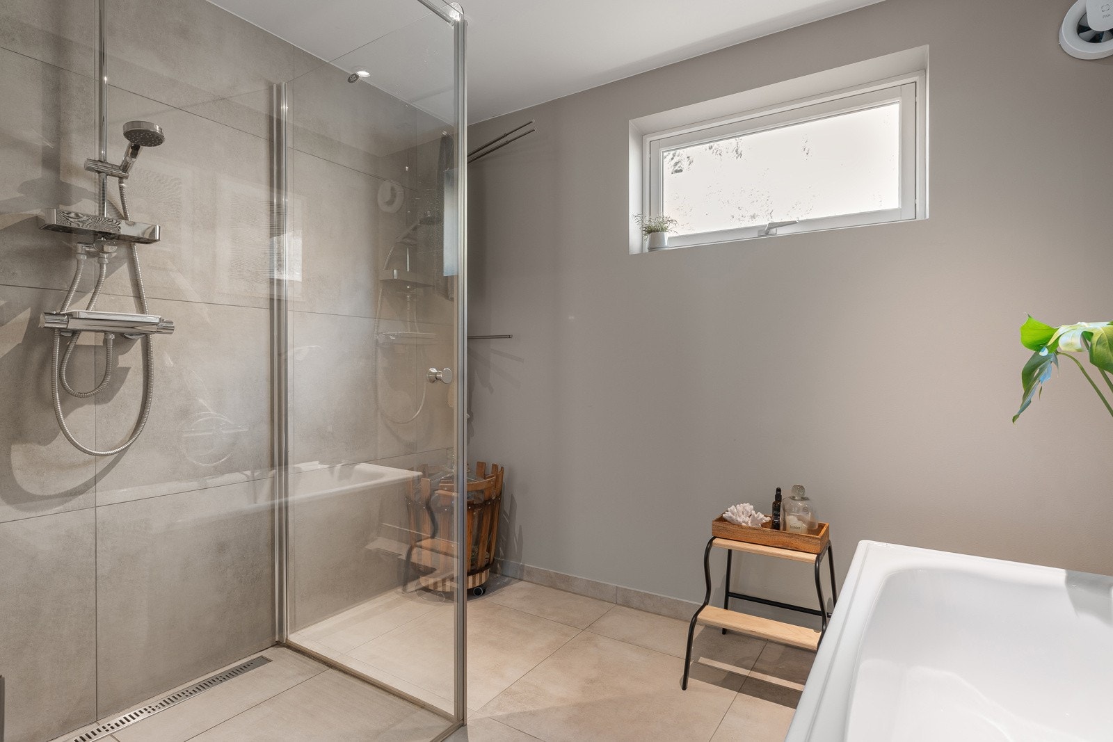 Badet er romslig og har plass til både dusjhørne, badekar og oppbevaring.