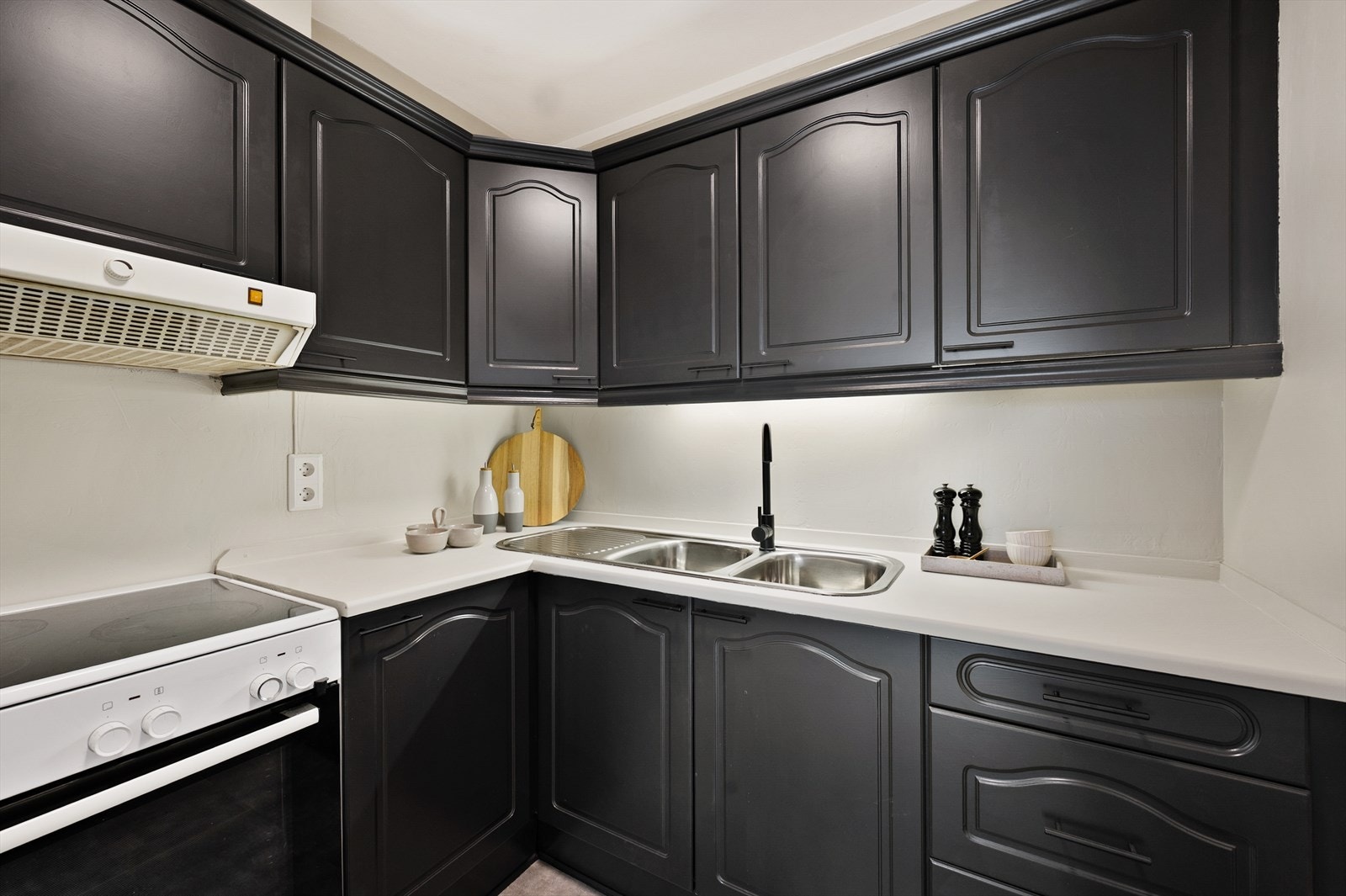 Tidløst kjøkken i svart utførelse og lyse benkeplater. Galleribilde