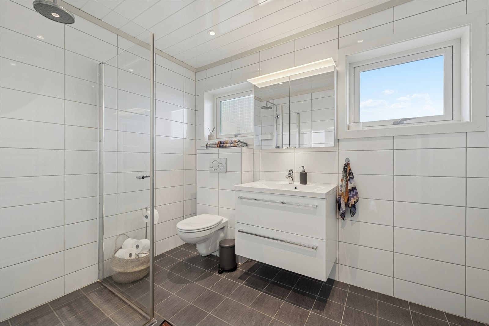 Boligen har et lyst og lekkert baderom med flislagt gulv og vegger. Galleribilde