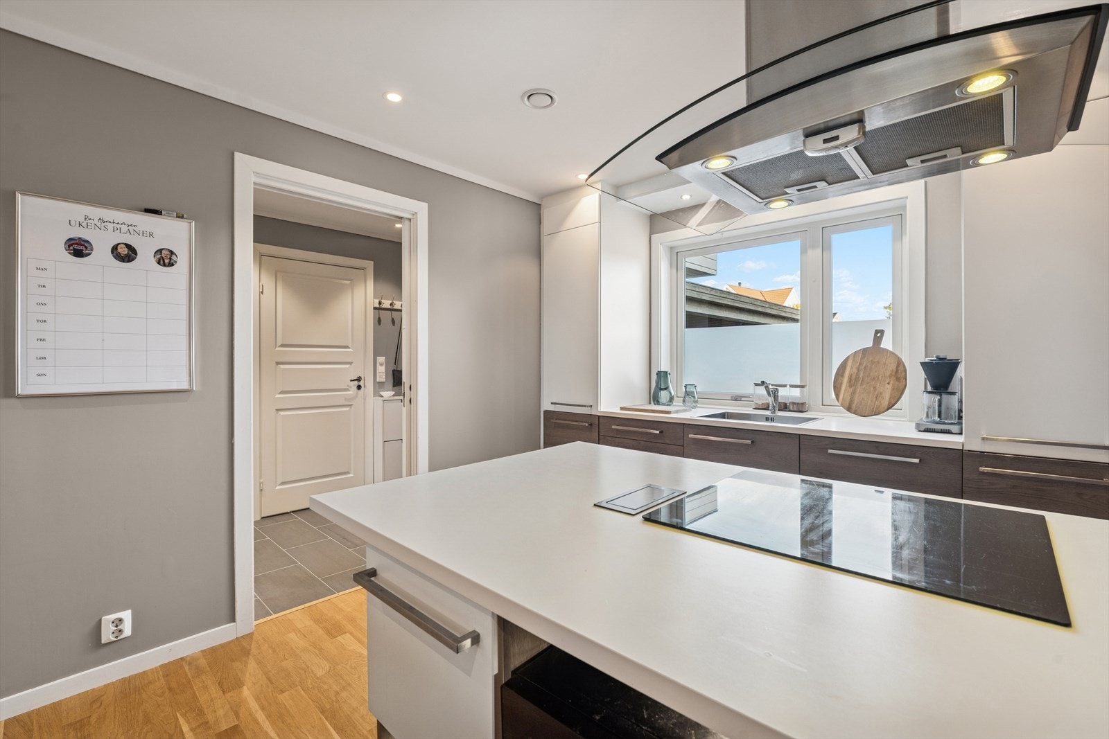 Kjøkkenøya blir en naturlig forlengelse av kjøkkenet, med blant annet nedfelt platetopp, takhengt ventilator og stilig belyst hylle- og skuffeoppbevaring. Galleribilde