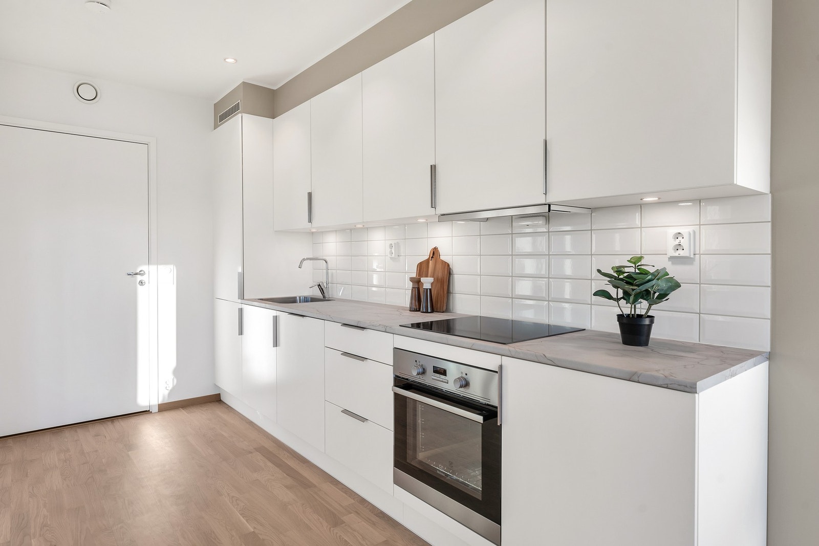 Stilrent og pent kjøkken med integrerte hvitevarer. Galleribilde