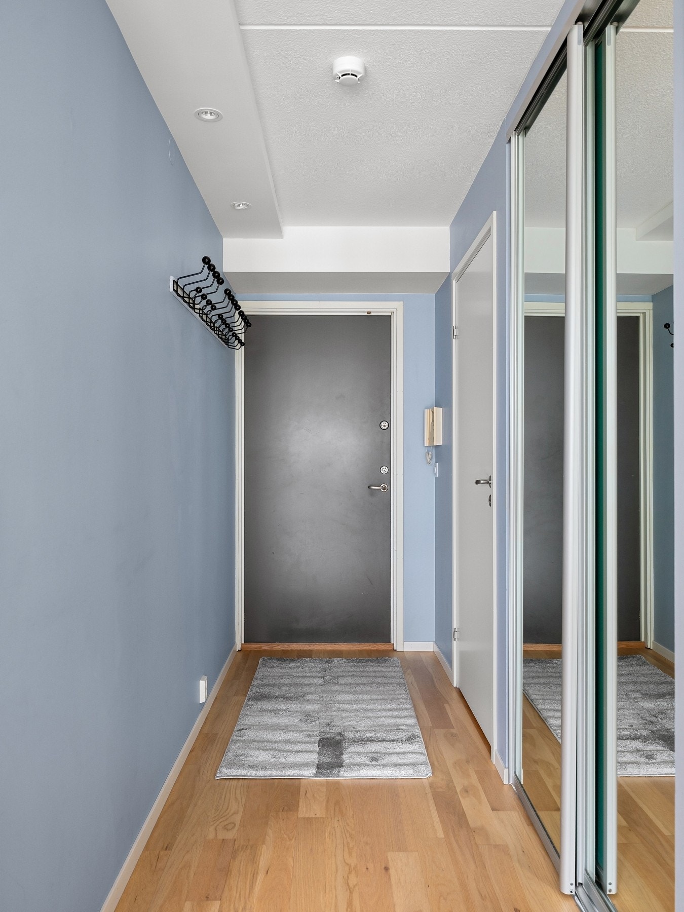 Innbydende entré med stor skyvedørsgarderobe med speilfronter. Galleribilde