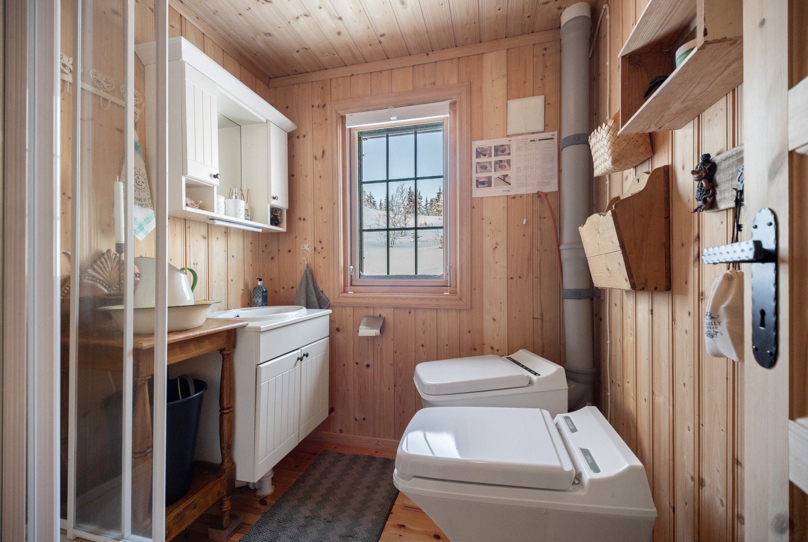 Det er etablert et enklere hyttebad med frittstående dusjkabinett, servantskap med plate og servant for håndvask. Toalettløsning med Cinderella forbrenningstoalett samt urinal. Galleribilde