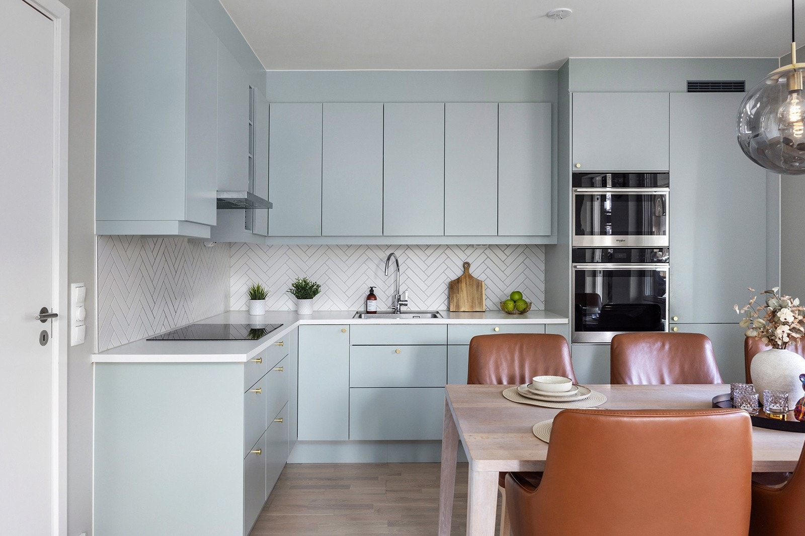 Kjøkkeninnredning med malte glatte fronter og integrerte hvitevarer. Galleribilde