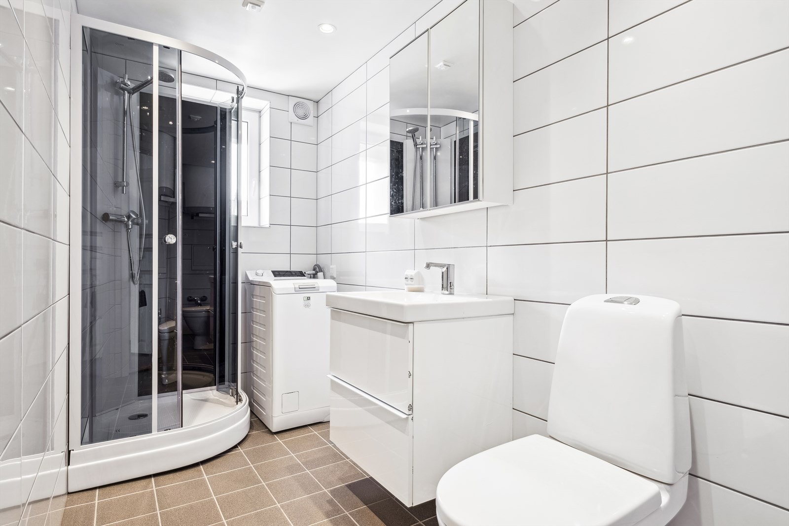 Flislagt bad med lys baderomsinnredning Galleribilde