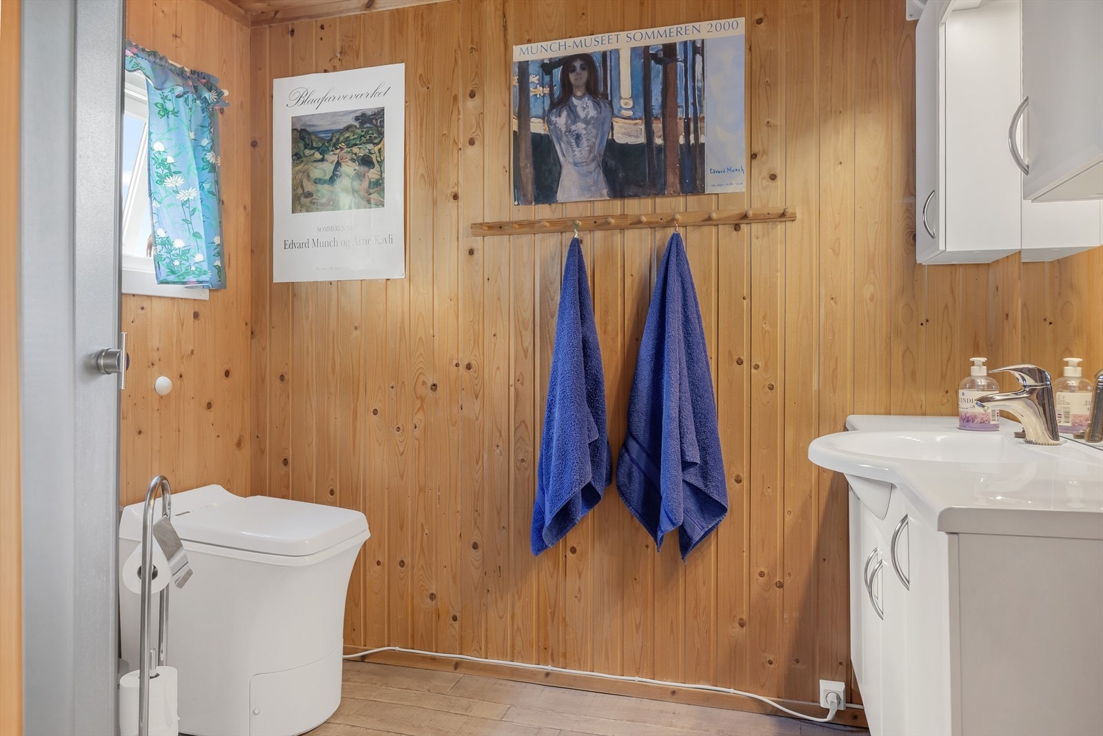 Hytta har et praktisk bad med gulvbelegg og varmekabler. Lys baderomsinnredning med over- og underskap, heldekkende servantplate, speil og belysning. På badet er det også dusjkabinett og Cinderella forbrenningstoalett. Galleribilde