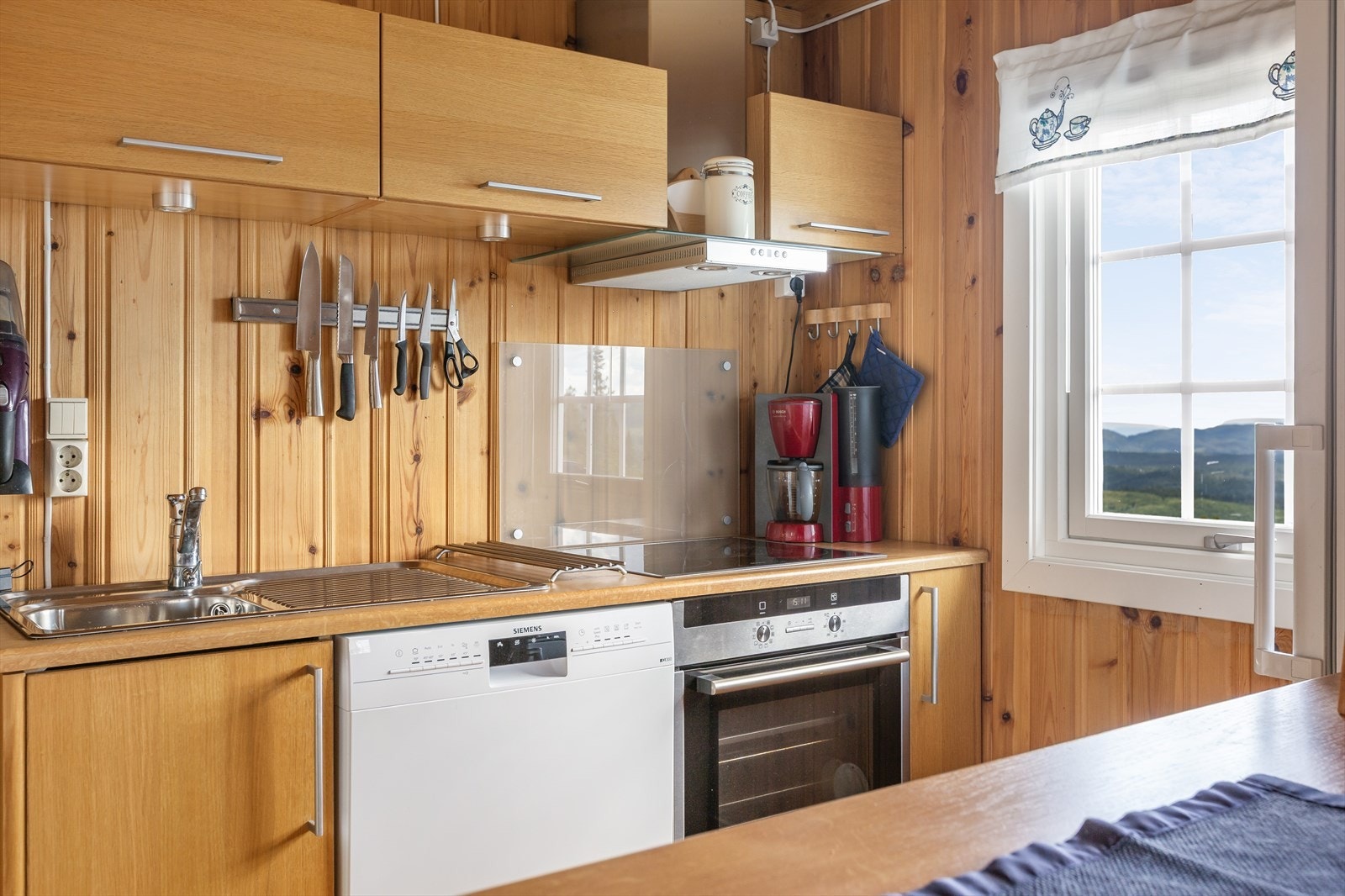 Kjøkkeninnredningen har integrerte hvitevarer med komfyr, induksjon koketopp, ventilator og ventilator. Galleribilde