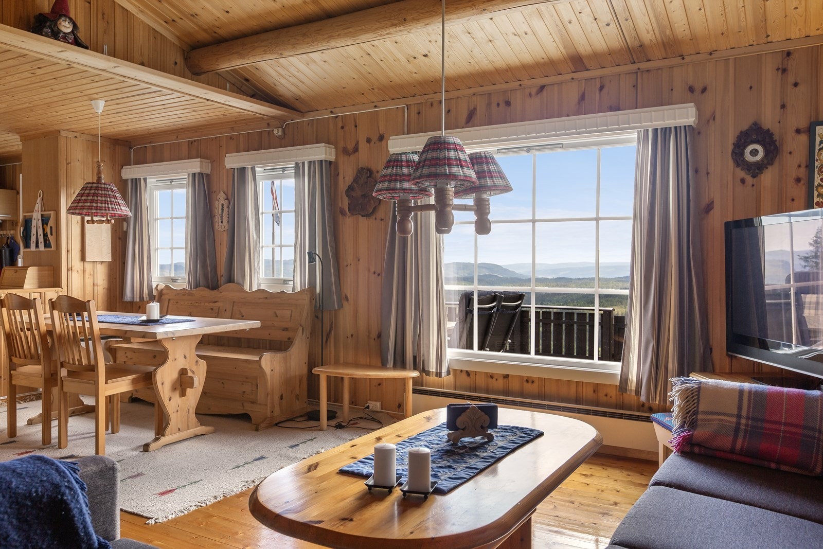 Den flotte utsikten kan nytes fra terrasse og uteplasser, men den kan også nytes inne fra hytta, gjerne fra sofakroken etter en aktiv dag ute i det fri. Galleribilde