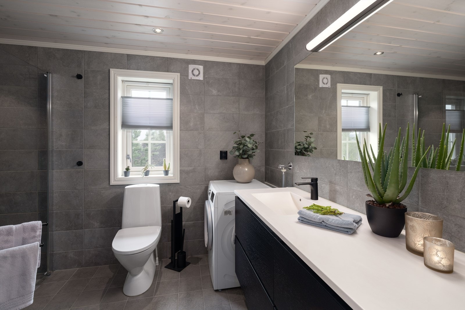 Badet er moderne med servantinnredning fra Kvik med steinplate, skap, dusjnisje. Galleribilde