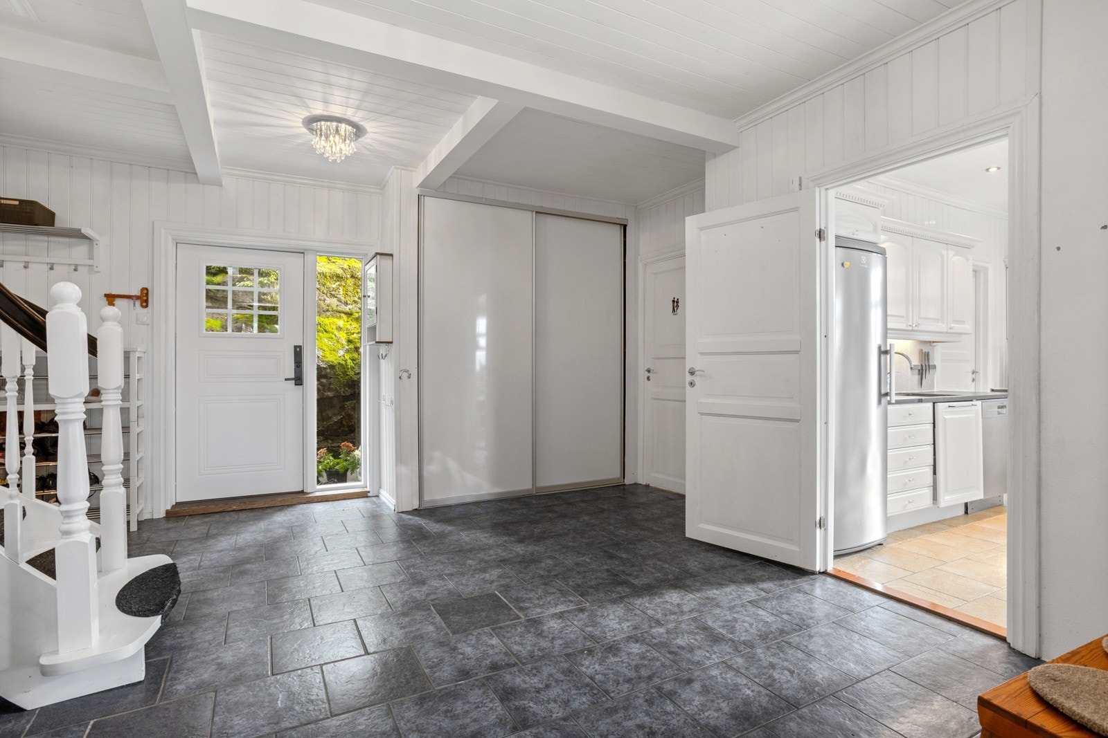 Det er skyvedørsgarderobe i hjørnet, samt plass til knagger og skohylle. Ytterdøren har praktisk kodelås. Galleribilde