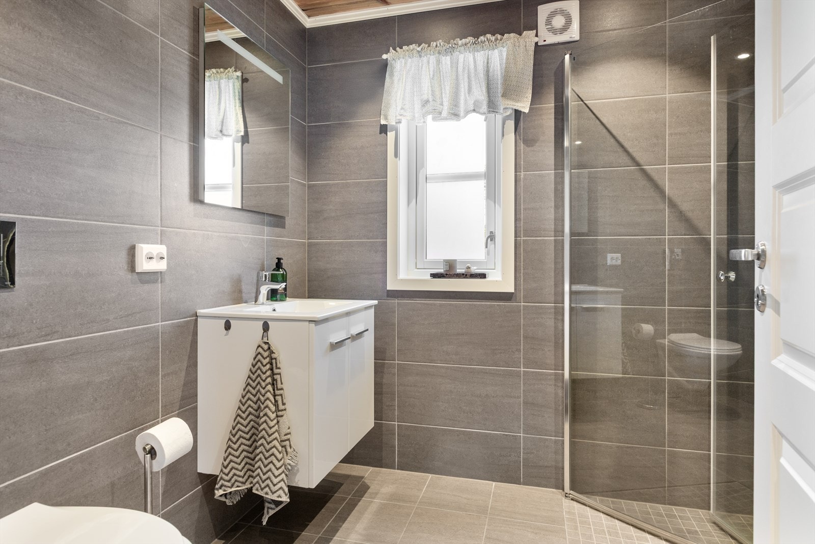 Hytta har et delikat bad med flislagte vegger og flislagt gulv med varmekabler. På badet er det opplegg for vaskemaskin. Galleribilde