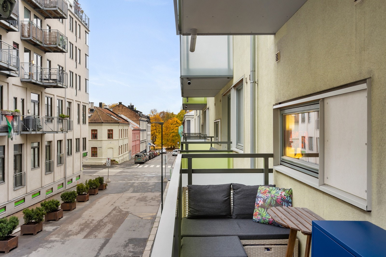 Fra balkong nedover gaten mot parken, Kiwi på hørnet Galleribilde