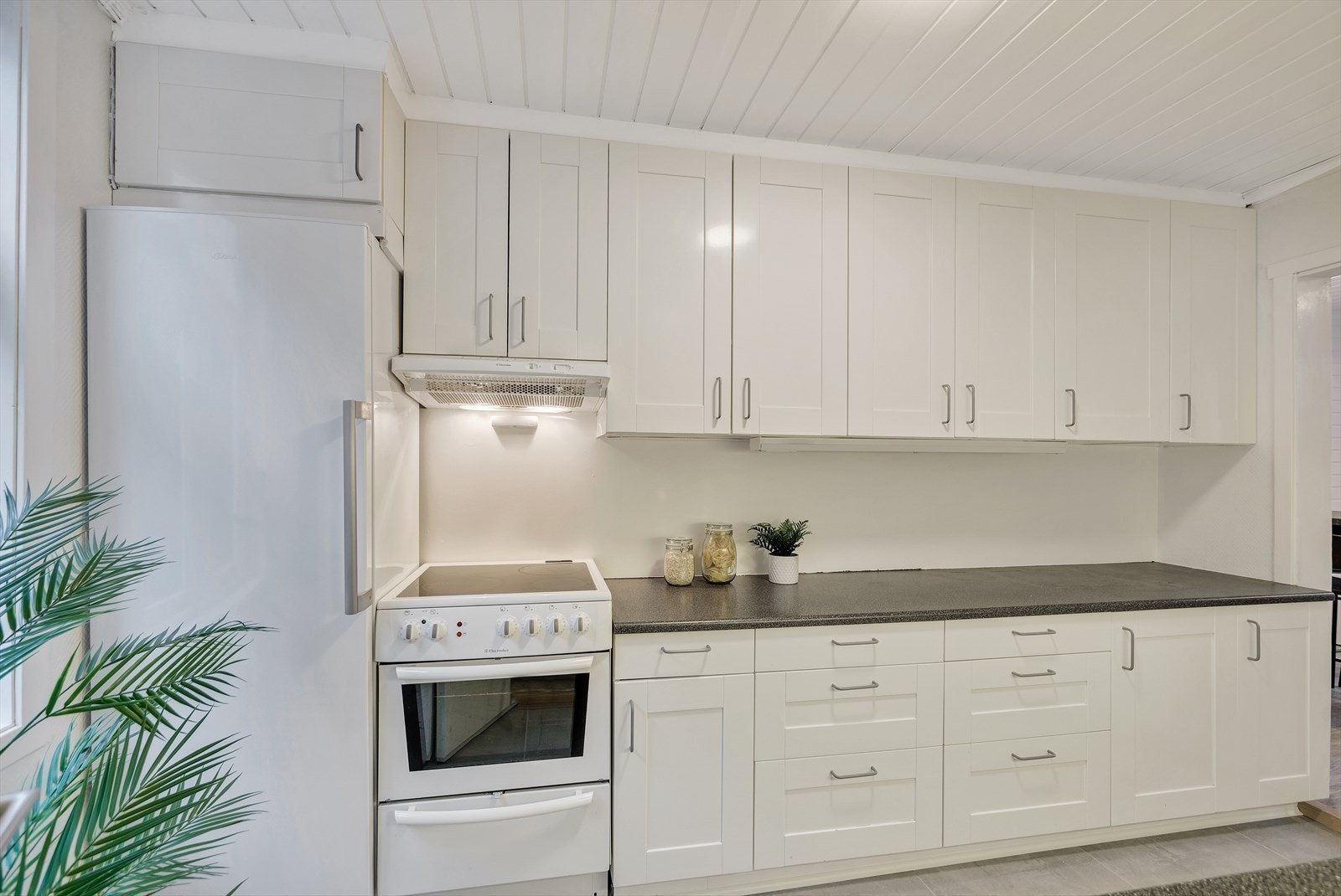 Kjøkkenet byr på gode arbeidsflater og rikelig oppbevaringsplass i både skuffer og skap. Galleribilde