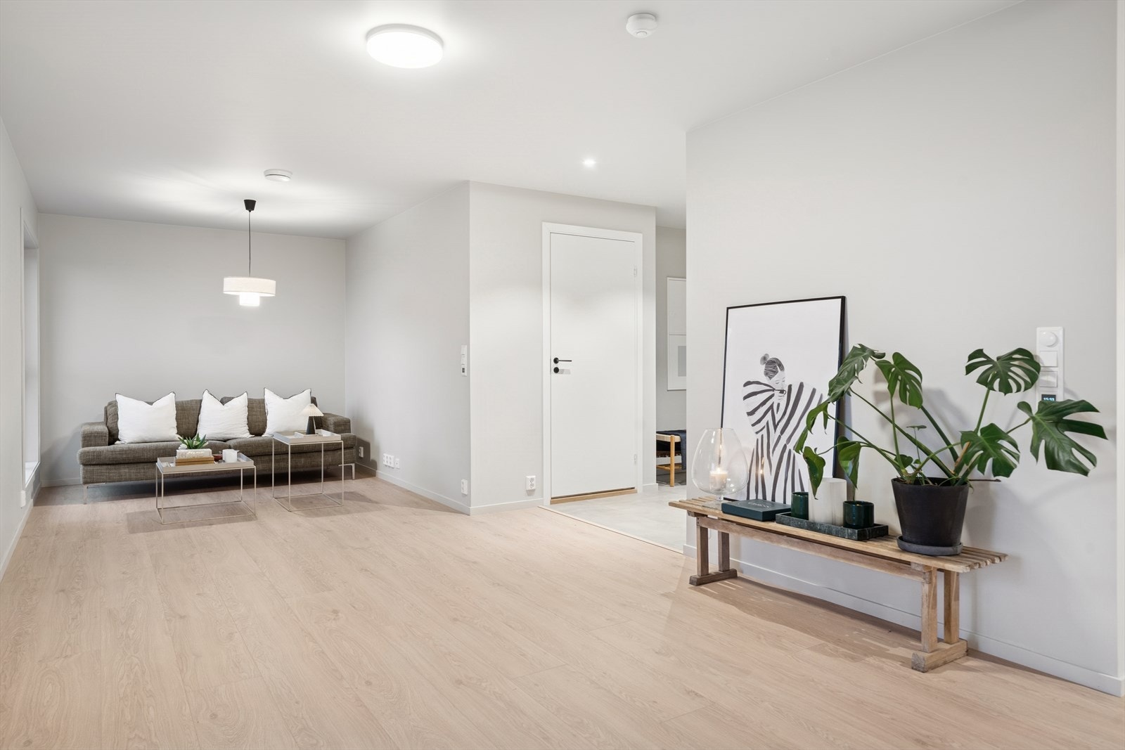 Lyst parkettgulv strekker seg gjennom stueområdet og gir et enhetlig uttrykk. Galleribilde