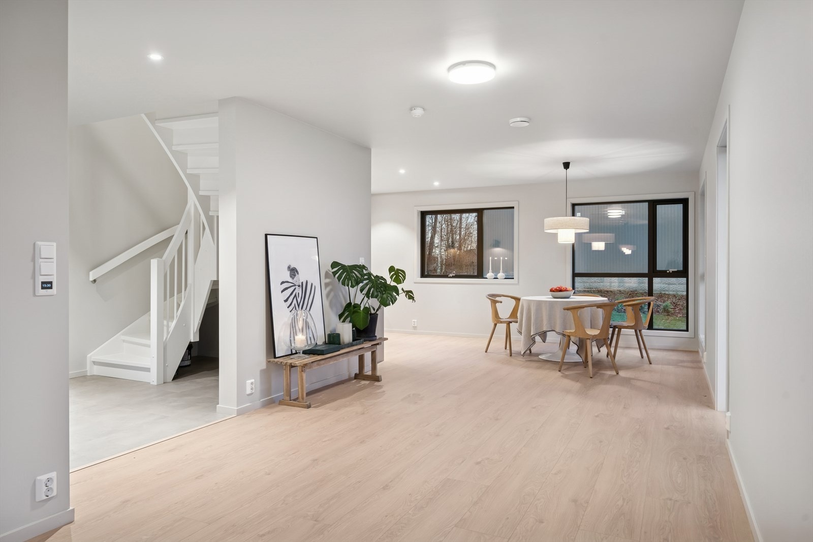 Store vinduer i stuen gir naturlig lys og utsyn mot hageområdet. Galleribilde