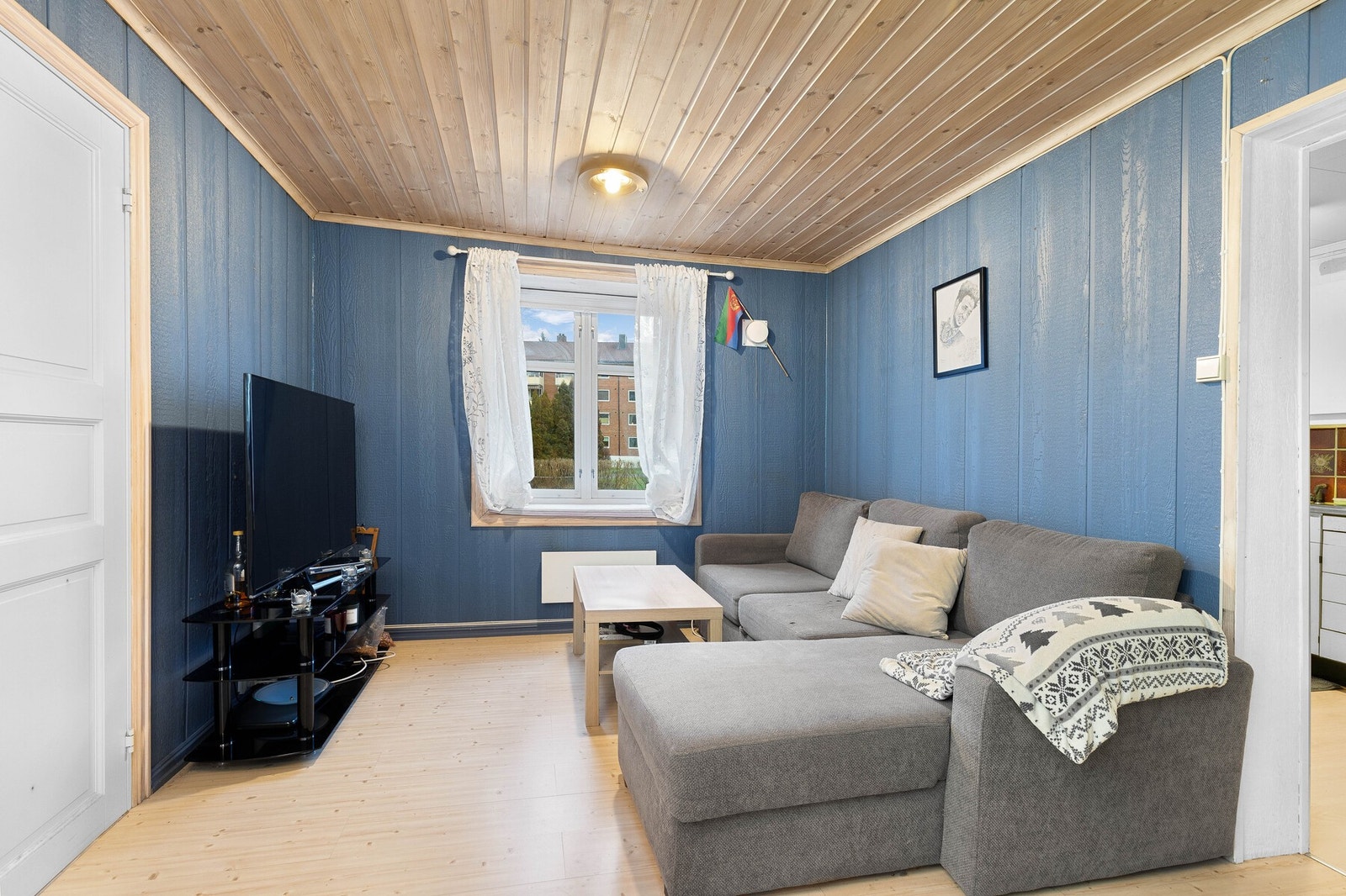 Stue med blåmalte vegger og lyst paneltak. Galleribilde