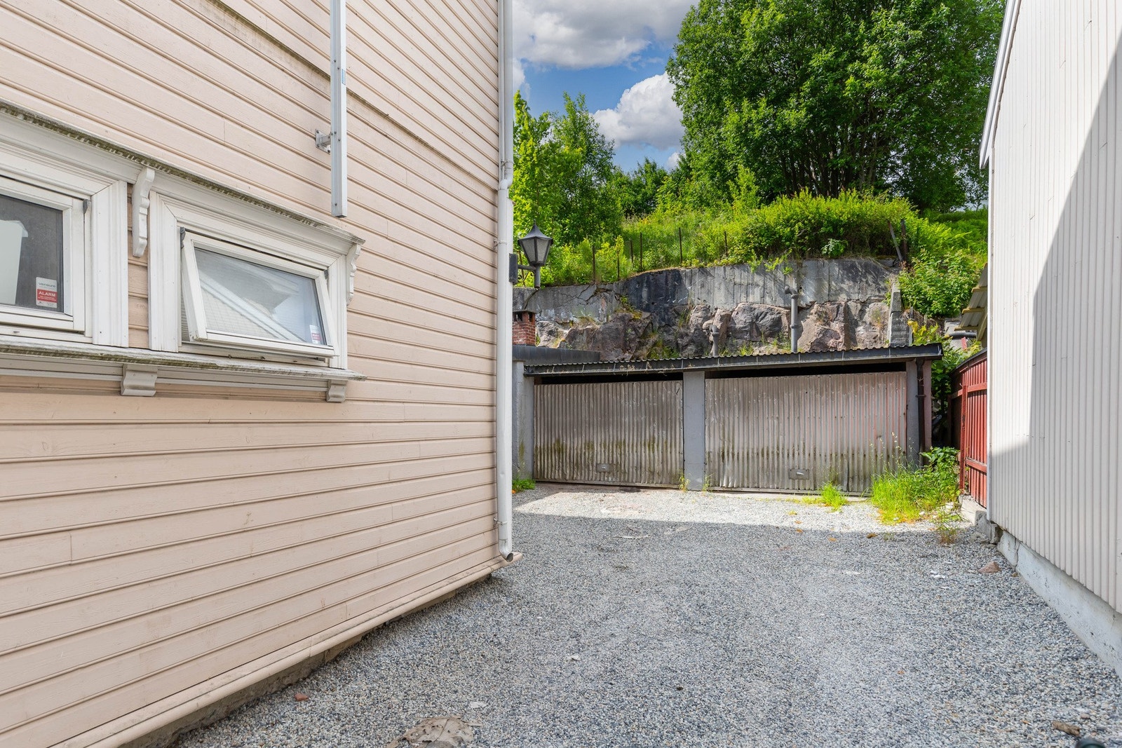 Ved gårdsplassen er det en stor dobbelgarasje i dårlig forfatning. Galleribilde