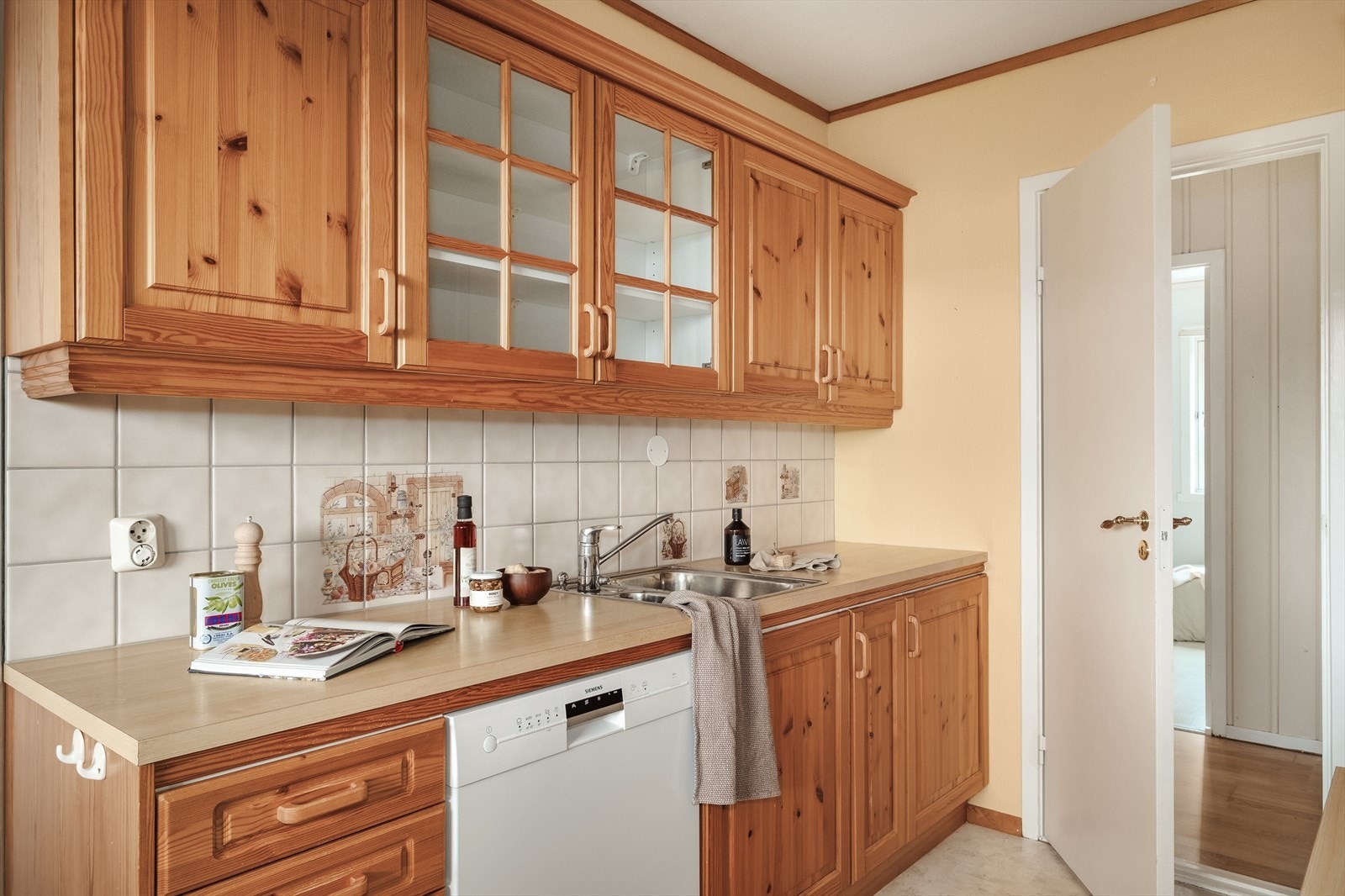 Leilighetens kjøkken måler 8,82 m² og er innredet med profilerte fronter, laminert benkeplate og oppvaskmaskin. Galleribilde