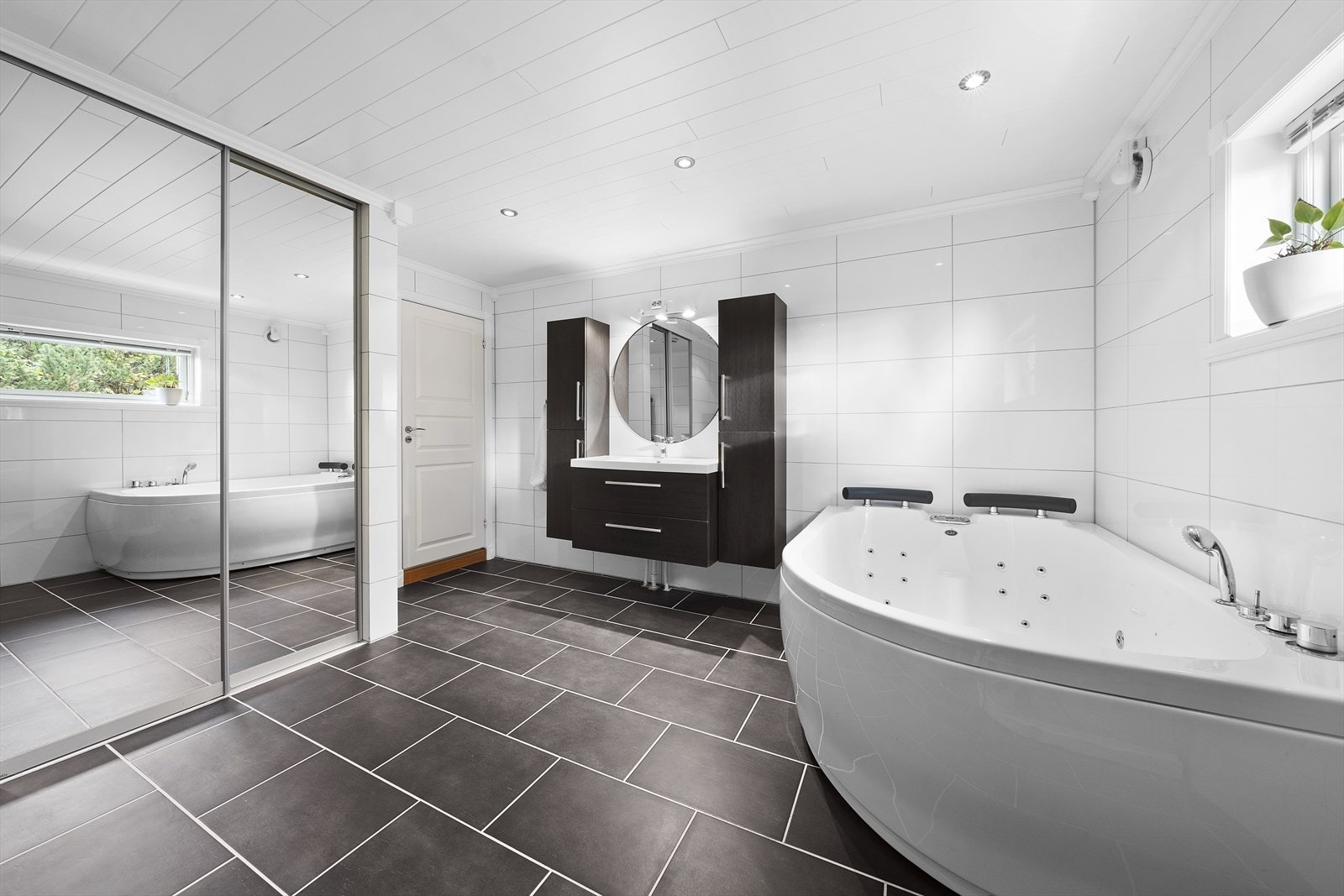 Lyst og romslig baderom med flislagt gulv med varmekabler Galleribilde