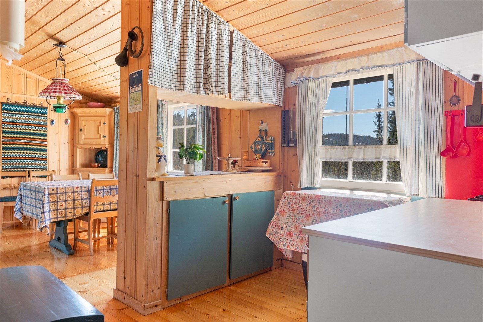 På kjøkkenet er det innredning med malte, glatte fronter, laminert benkeplate og skrog av platemateriale. Noen av overskapene har forheng av stoff. Galleribilde