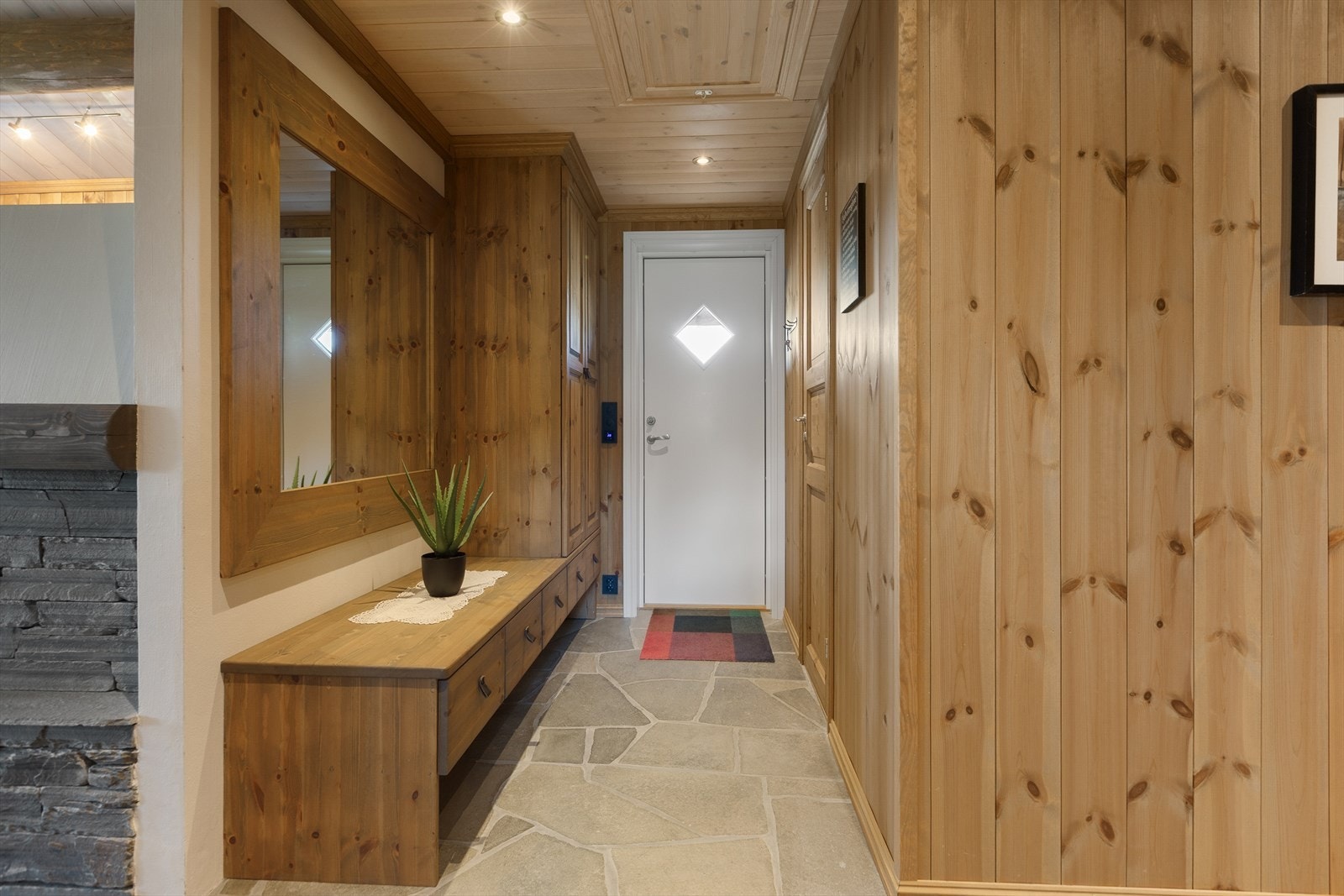 Entreen har praktisk gulv med skiferheller og varmekabler, så her tørker klær og sko raskt etter en aktiv dag ute i frisk natur. Galleribilde