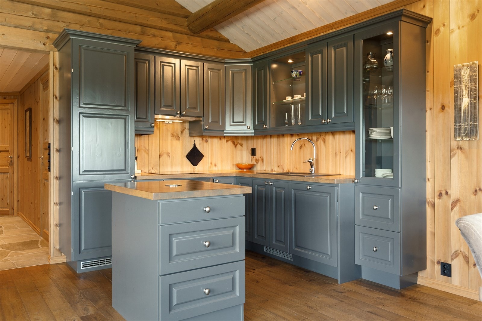 Kjøkkenet har stilig innredning i heltre med over- og underskap, heltre benkeplate i eik og oppvaskkum av kompositt med kran av stål. En liten kjøkkenøy med skuffer gir ekstra oppbevaringsplass og benkeplass. Galleribilde