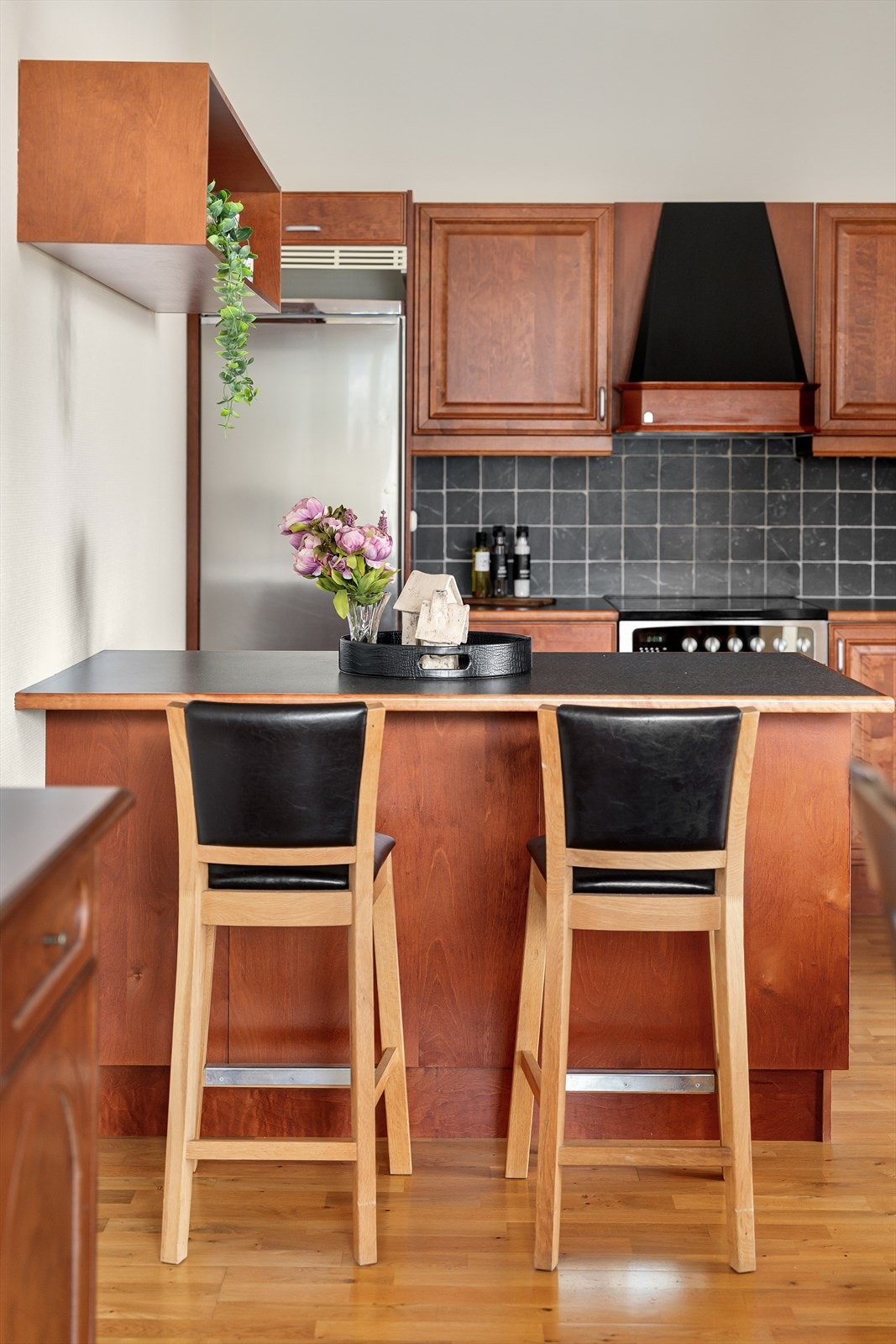 Den funksjonell kjøkkenøyen gir rom for oppbevaring, ekstra arbeidsplass og sitteplass. Galleribilde