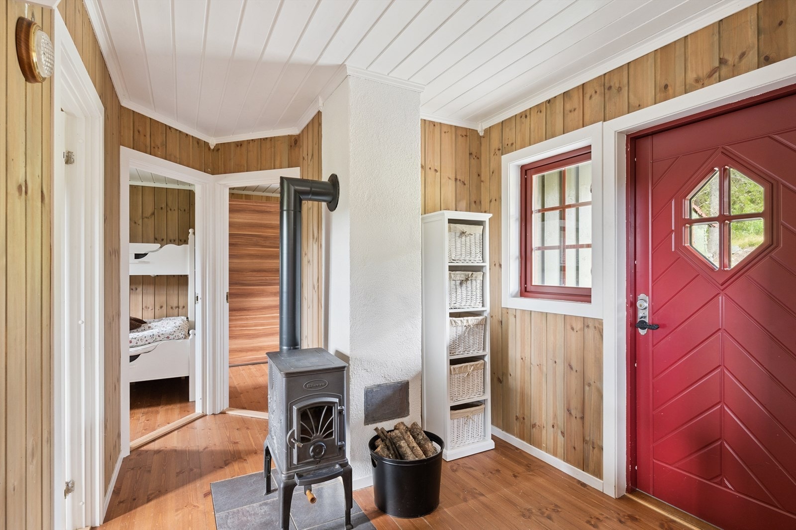 Fra det overbygde inngangspartiet kommer du inn i entré med plass til yttertøy og sko. En vedovn sørger for ekstra varme på kalde dager. Galleribilde