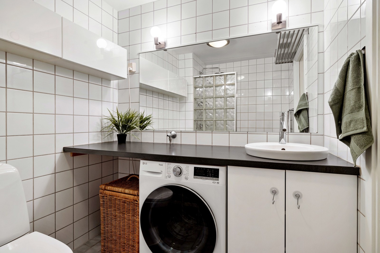 På veggen henger det overskap som gir god oppbevarringsplass. Det er gulvstående toalett og opplegg for både vaskemaskin og tørketrommel under benkeplaten. Galleribilde