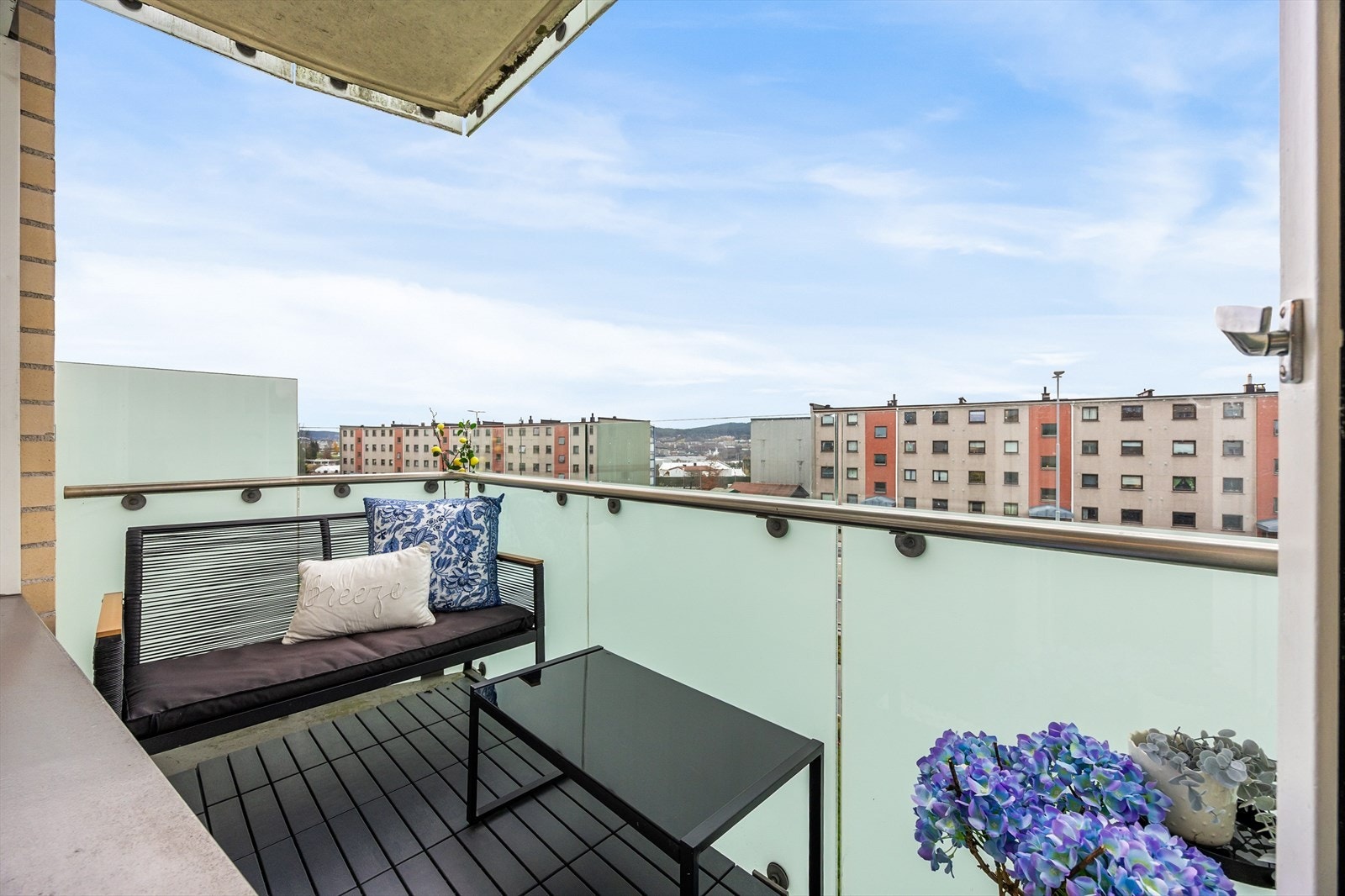 Balkonggulvet er belagt med treflisbelagt betong og rekkverket er av frostet glass og metall Galleribilde