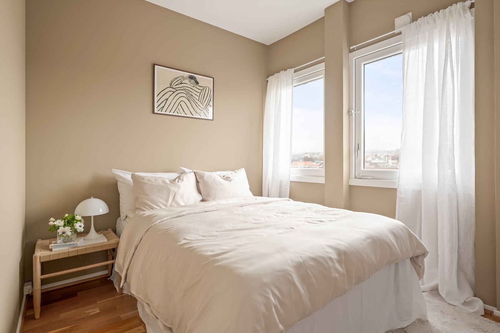 Romslig hovedsoverom med store vindusflater som gir en nydelig utsikt over byens tak. Galleribilde